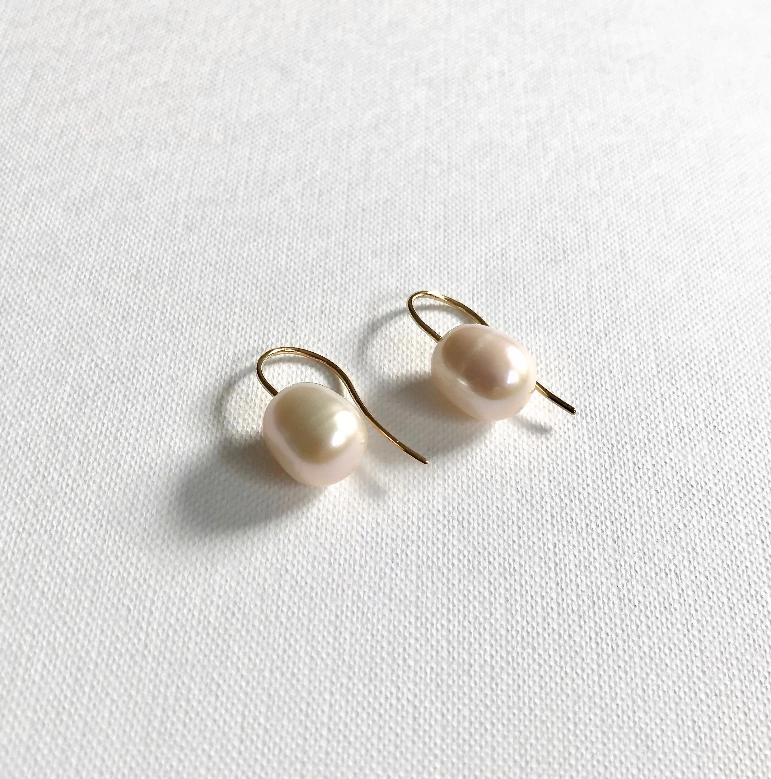18 Karat solid yellow gold freshwater cultured pearl hook earrings. 
Each pearl is unique due to its nature. They may vary in shapes and colours from pastel shades of pink to creamy white.  We have tried our best to match each pair as close as