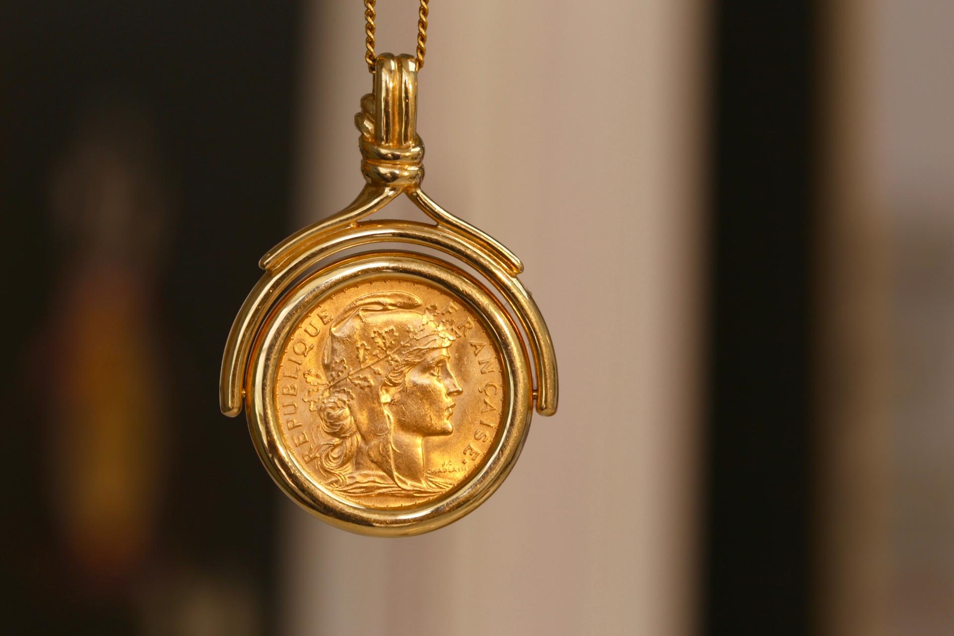 This intriguing pendant necklace brings the focus to the 20 Franc Marianne Rooster coin from 1912. It is set so that it can spin on its axis to reveal which side you want. Either Marianne, a symbol of the French Republic, or the Gallic rooster can