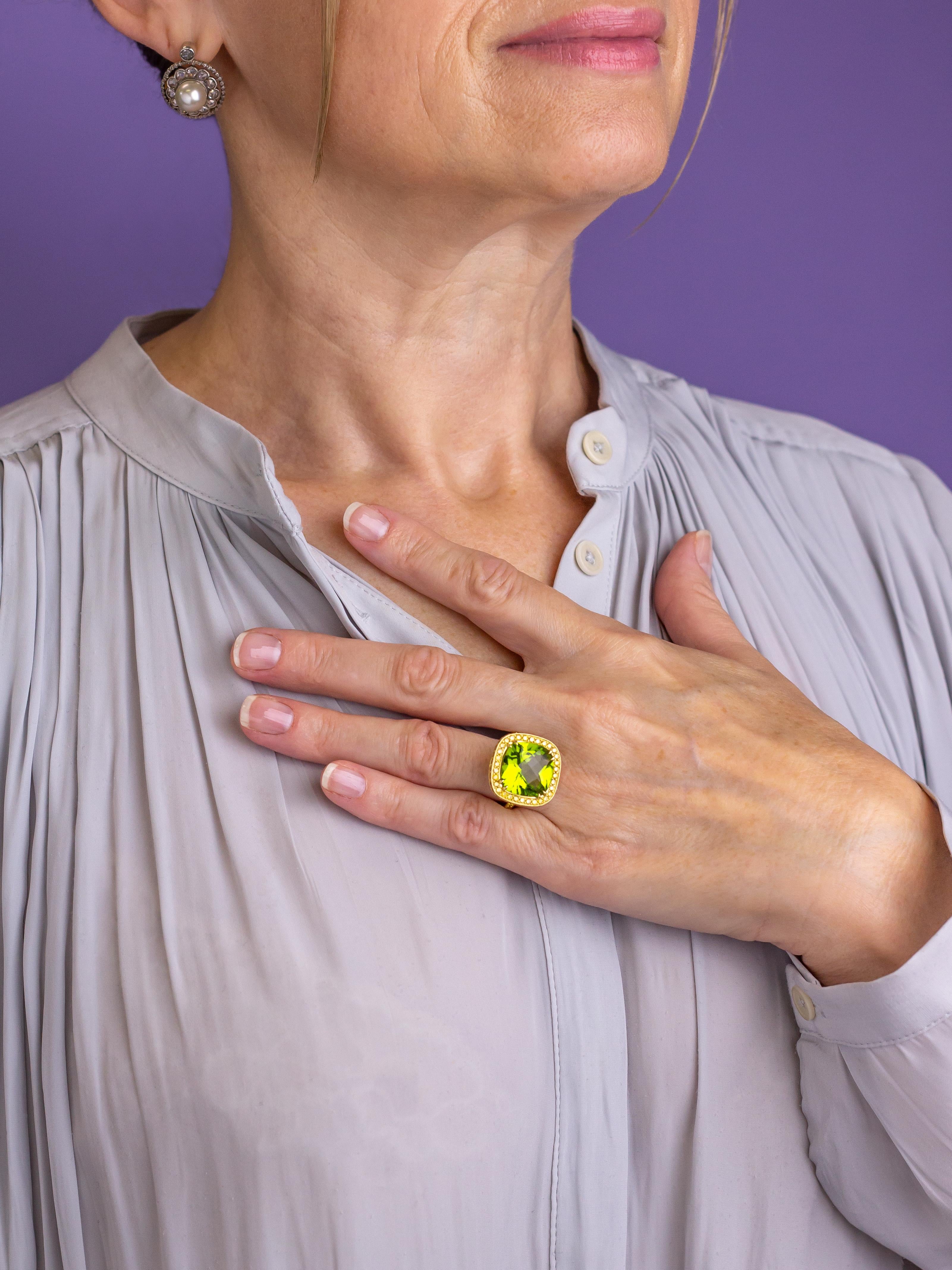 This 18 karat yellow gold ring is likely a copy of a 'Nardi' design originating in Italy. The cast 18 karat yellow gold ring centres on a 12 carat 'square cushion checkerboard cut' green peridot which is classed as 'bright mid yellowish green very