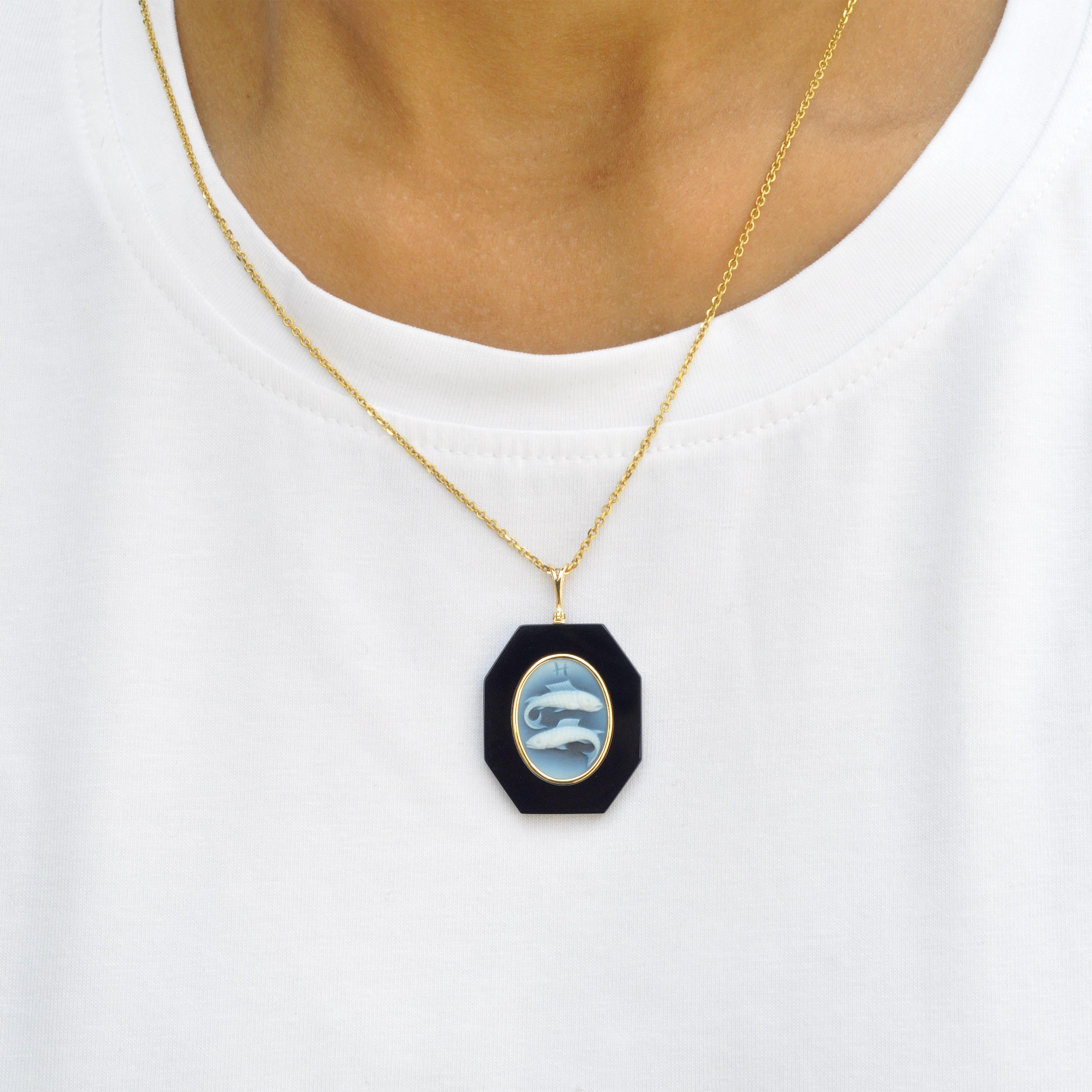 18 karat yellow gold Pisces zodiac agate cameo black onyx pendant necklace. 

This exquisite pendant showcases a stunning combination of contemporary design and timeless elegance. Crafted in 18K gold, the piece features a sleek loop from which a
