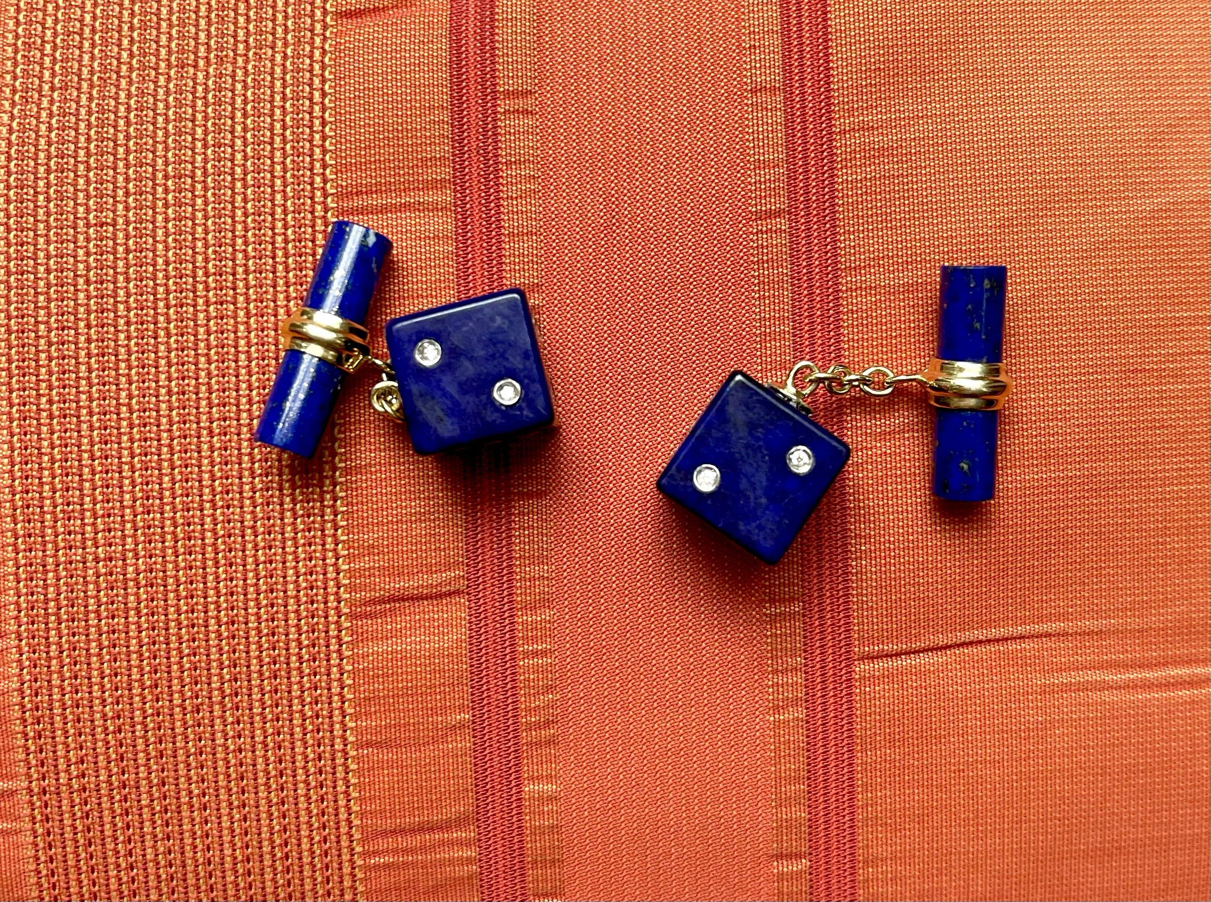 This sophisticated and particular pair of cufflinks is entirely made of lapis lazuli and it features a simple, cylindrical toggle attached to the front with an 18 karat yellow gold post. 
The front face is shaped as a cube with its striking deep