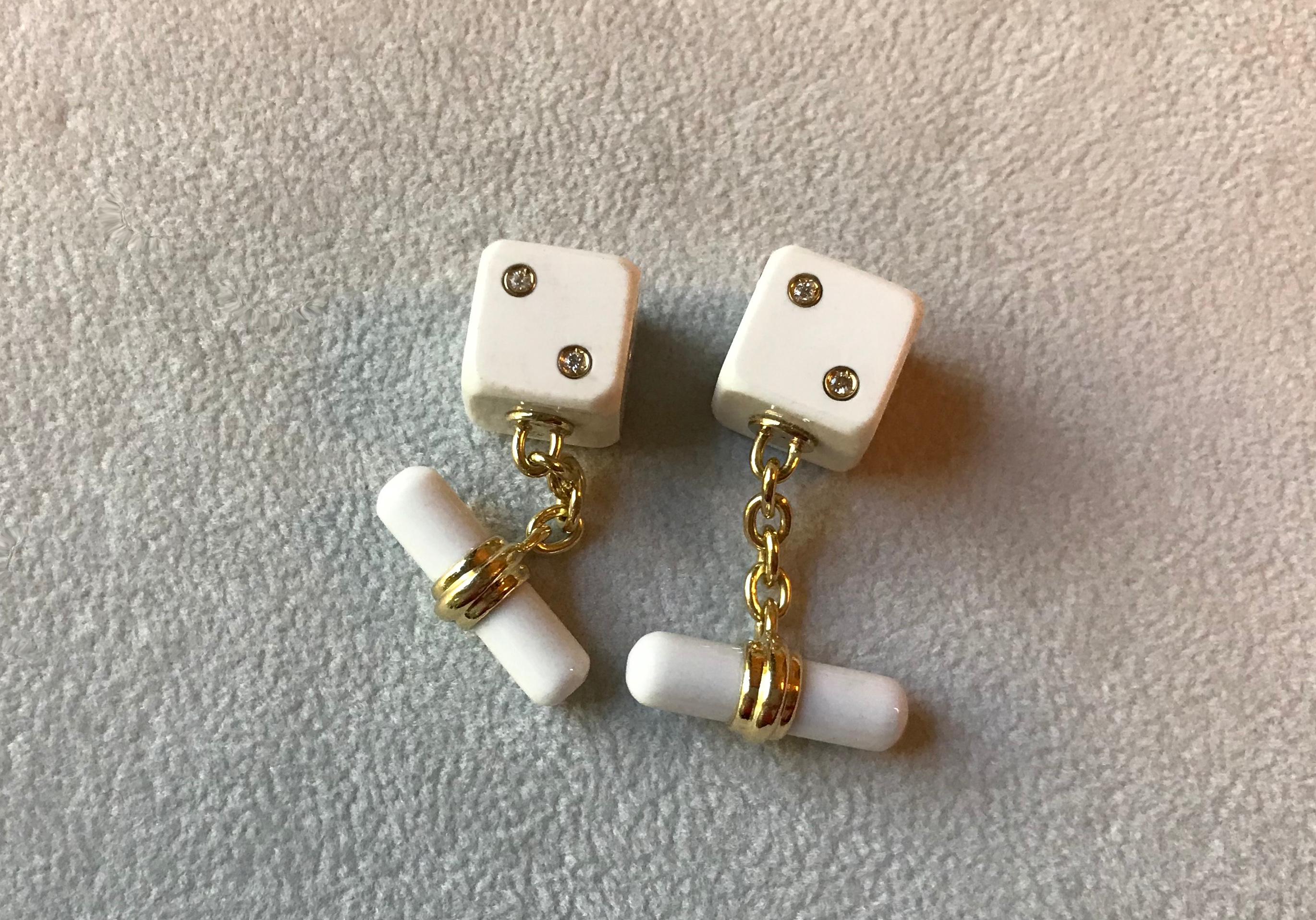 This sophisticated pair of cufflinks is entirely made of white agate and it features a simple, cylindrical toggle attached to the front with an 18k yellow gold post. 
The front face is shaped as a cube with its striking white surface highlighted by