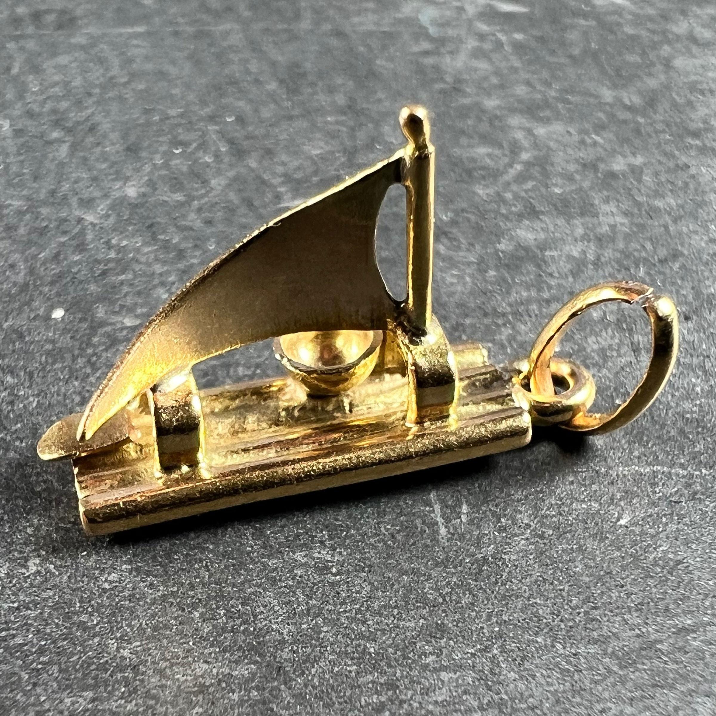 An 18 karat (18K) yellow gold charm pendant designed as a raft with a sail and rudder. Unmarked but tested for 18 karat gold. 

Dimensions: 1.8 x 0.55 x 1.1 cm
Weight: 1.78 grams
