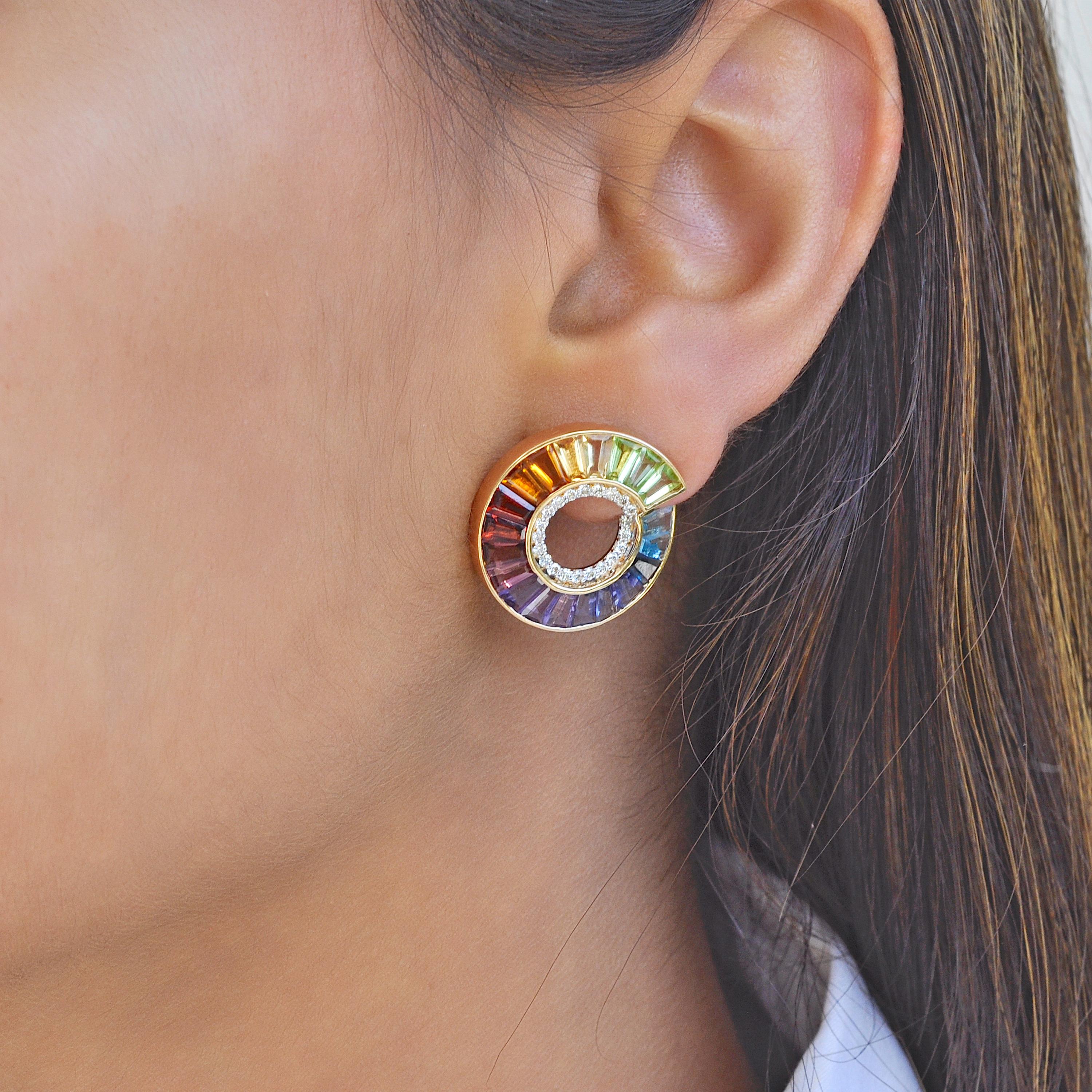 These 14 karat yellow gold rainbow tapered baguettes curve diamond earrings are a captivating blend of elegance and color. These earrings feature a graceful twist design adorned with vibrant rainbow gemstones.

Each rainbow gemstone featuring blue