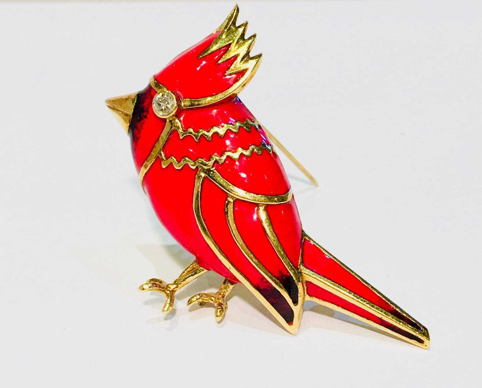 18 karat yellow gold brooch with predominantly red enamel overlay is a stylized Cardinal bird with a bezel set diamond eye .

Diamond measures 3mm in diameter and weighs approximately .11 carats. 

Face of brooch pin measures 37.27 mm x 52.64 mm x