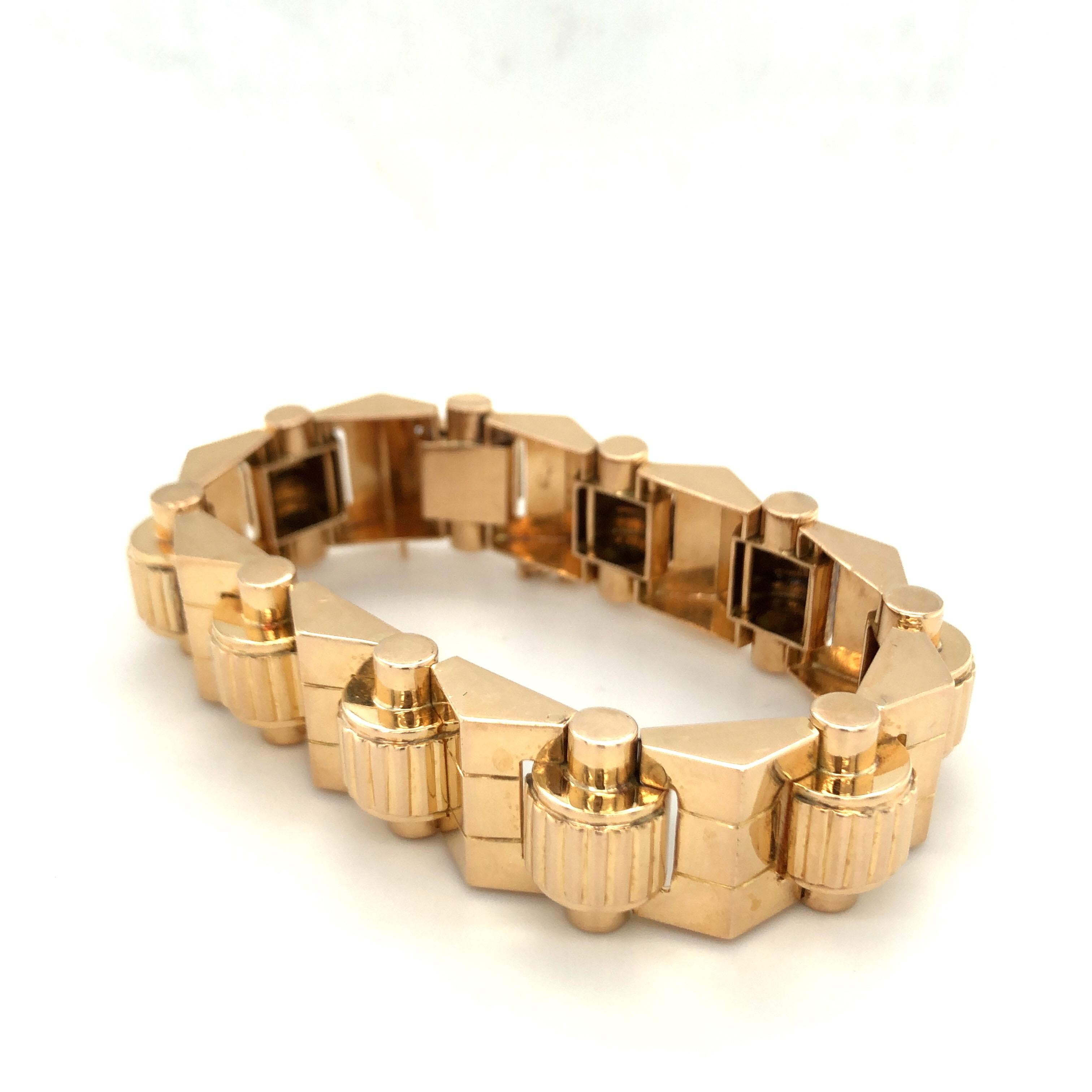 Fabulous 18 karat yellow gold retro machine age French tank bracelet, circa 1945.
Articulated geometric gold band composed of pyramidal and tubular panels with reeded details. The clasp of the bracelet is disguised seamlessly within the final link