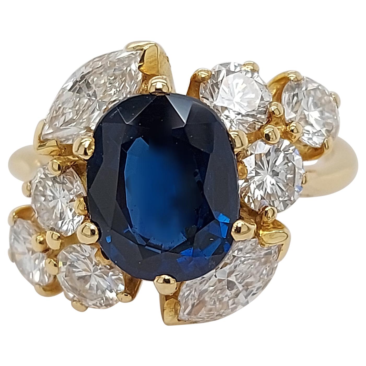18 Karat Yellow Gold Ring with Oval Sapphire, Marquise and Round Cut Diamonds