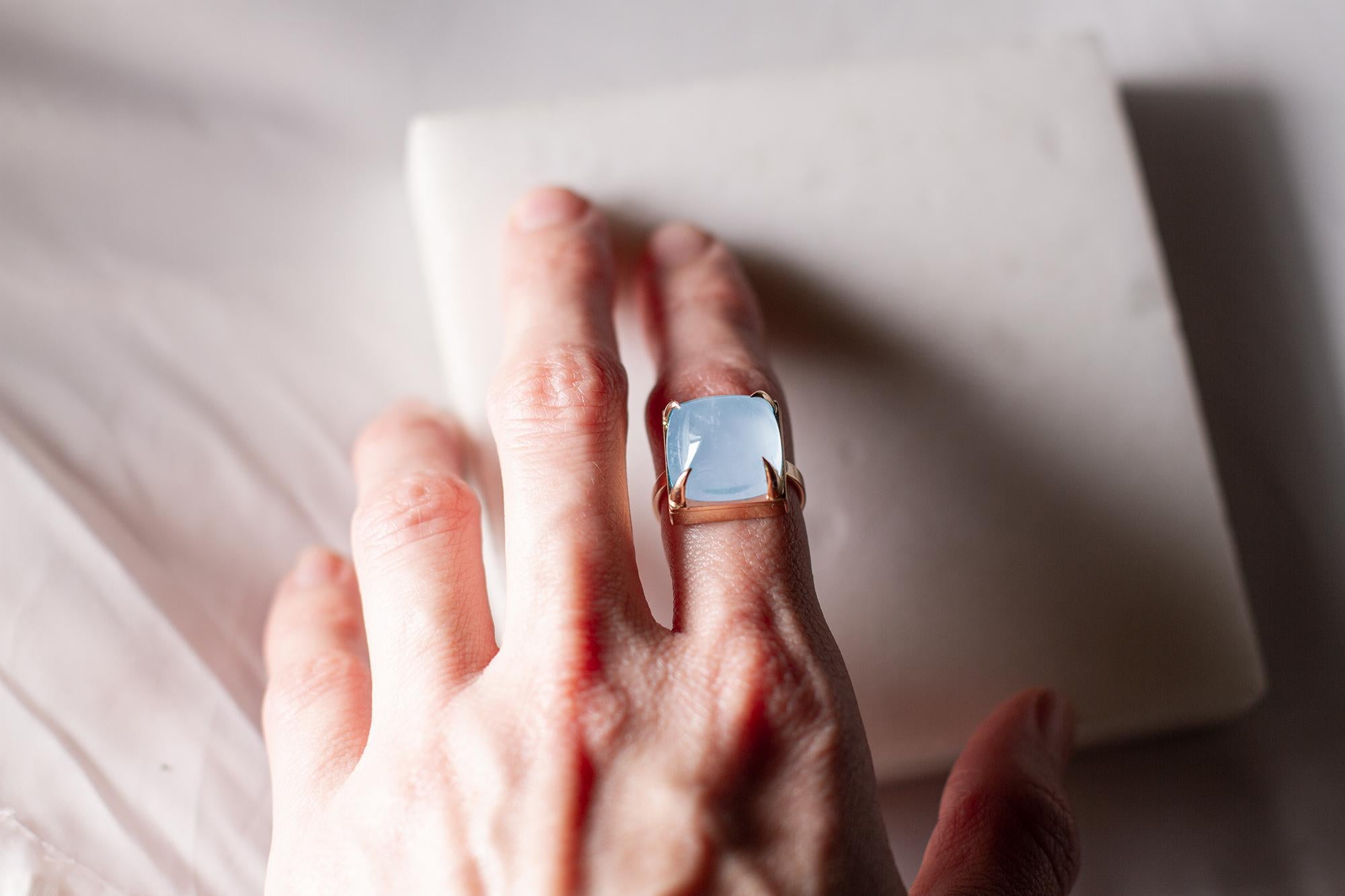 This ring is made of 18 karat yellow gold and sugarloaf cut aquamarine.

When for most of the gem it works the way: the smaller prongs the better. This is the shape and size of the gem that we really enjoy to see avoiding the typical for sugarloaf