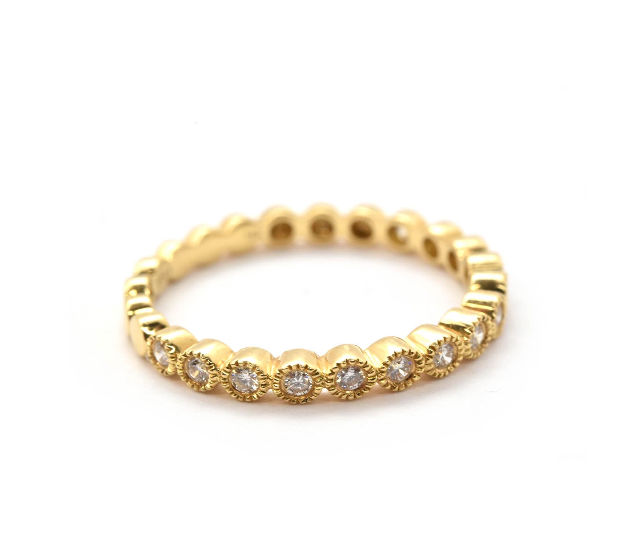 This is a simple yet intricately made diamond band fashioned from 18k yellow gold. Diamonds are bezel set into the front of the band, each diamond has a bezel with a granulated trim. The other side of the band is made in oval shapes. Total carat