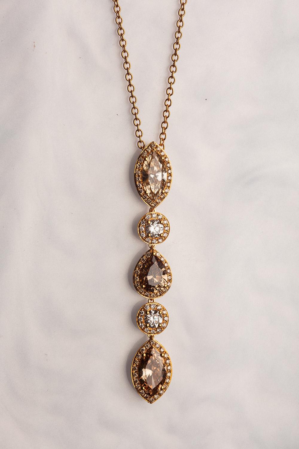 This 18K yellow gold elegant pendant is from our Divine Collection. It is made of 2 marquise shape brown diamonds in total of 2.04 Carat, pear shape brown diamond in total of 1.04 Carat and 2 round colorless diamonds in total of 0.52 Carat. All