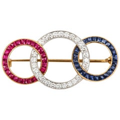 18 Karat Yellow Gold Ruby Diamond and Sapphire 'Tri-Ring' Brooch Circa 1950s