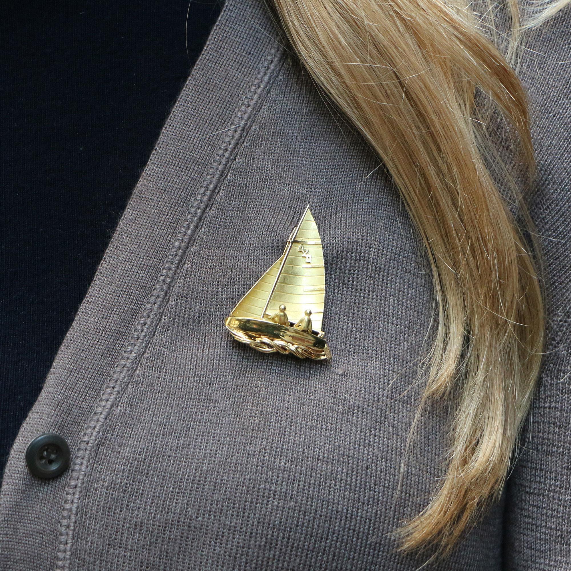 A beautifully detailed yellow gold sailing boat/yacht brooch made of solid 18k yellow gold. The brooch depicts a boat at full speed on the open ocean complete with two crew on board. 

The polished and brushed gold sections give this piece even more