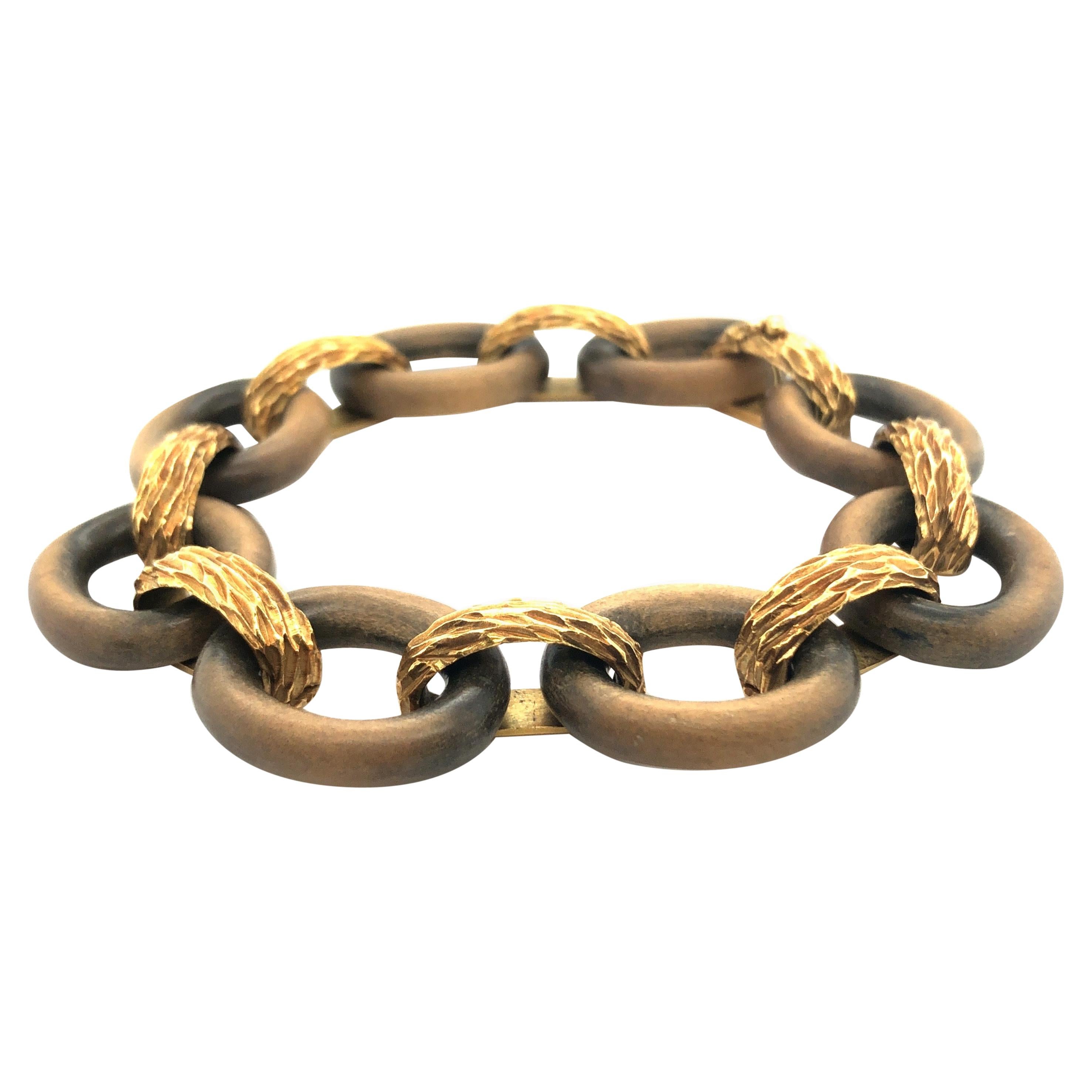 18 karat yellow gold and sandalwood vintage bracelet by René Boivin, consisting of 8 oval rings of polished sandalwood joined together by structured yellow gold links. The bracelet fastens with a secure clasp disguised within the final link. A