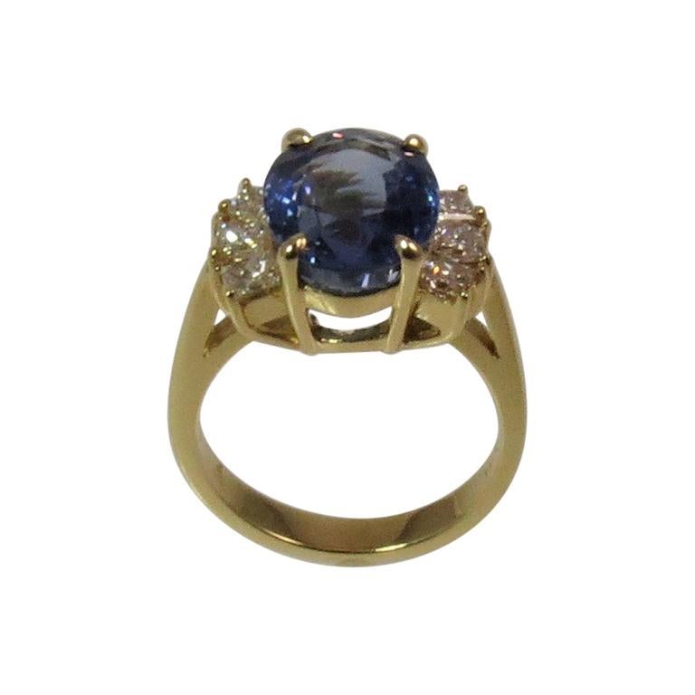 18K yellow gold ring, prong set with one Oval blue sapphire weighing 5.65cts and 6 Princess cut diamonds weighing .60cts, GH color, VS-SI1 clarity
Finger size 5.75
May be sized