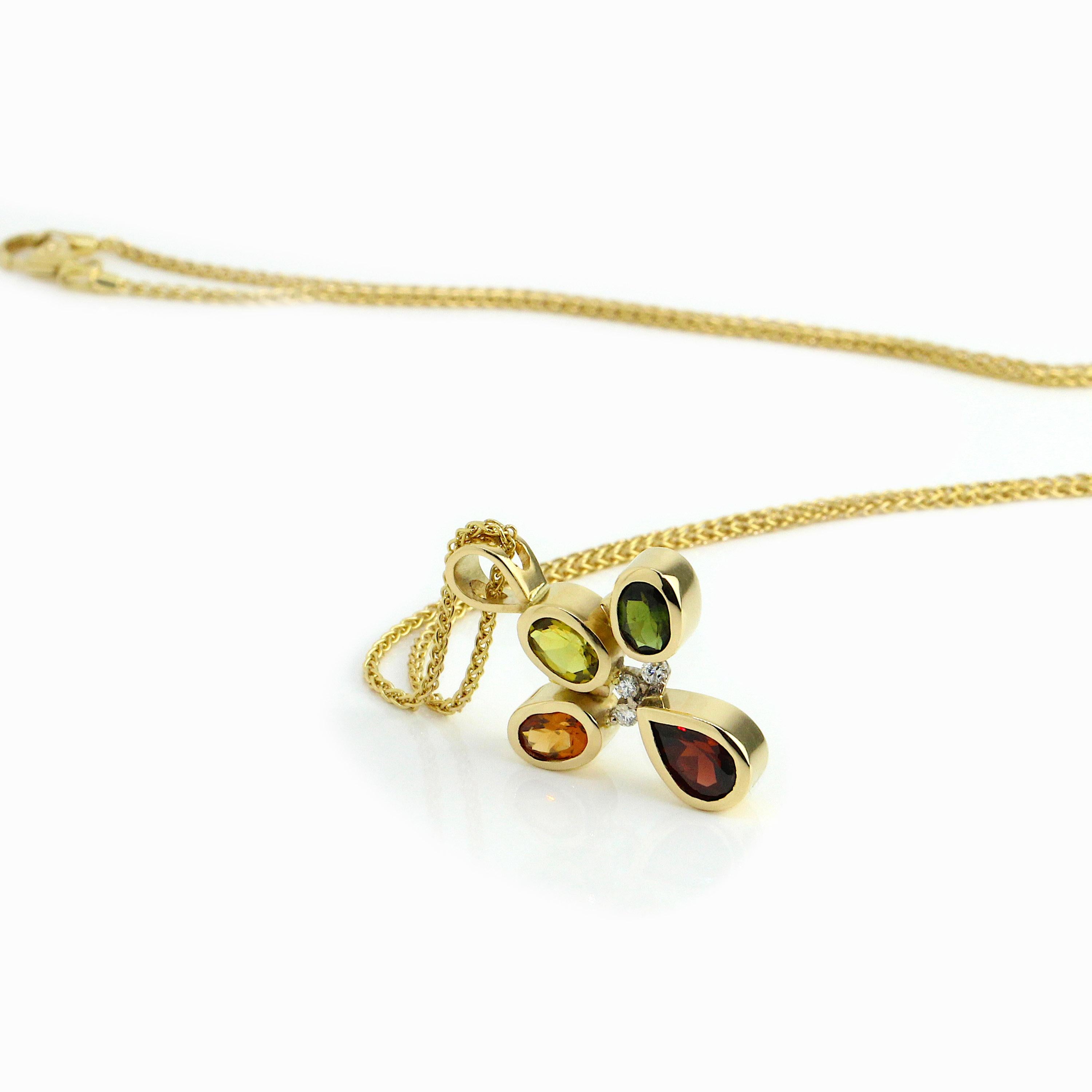 An exquisite one of a kind 18k yellow gold pendant set with a beautiful selection of complimentary gems, yellow sapphire, orange and red garnet, green tourmaline and white diamonds. An exquisite eye-catching feminine flowing geometric 18k yellow