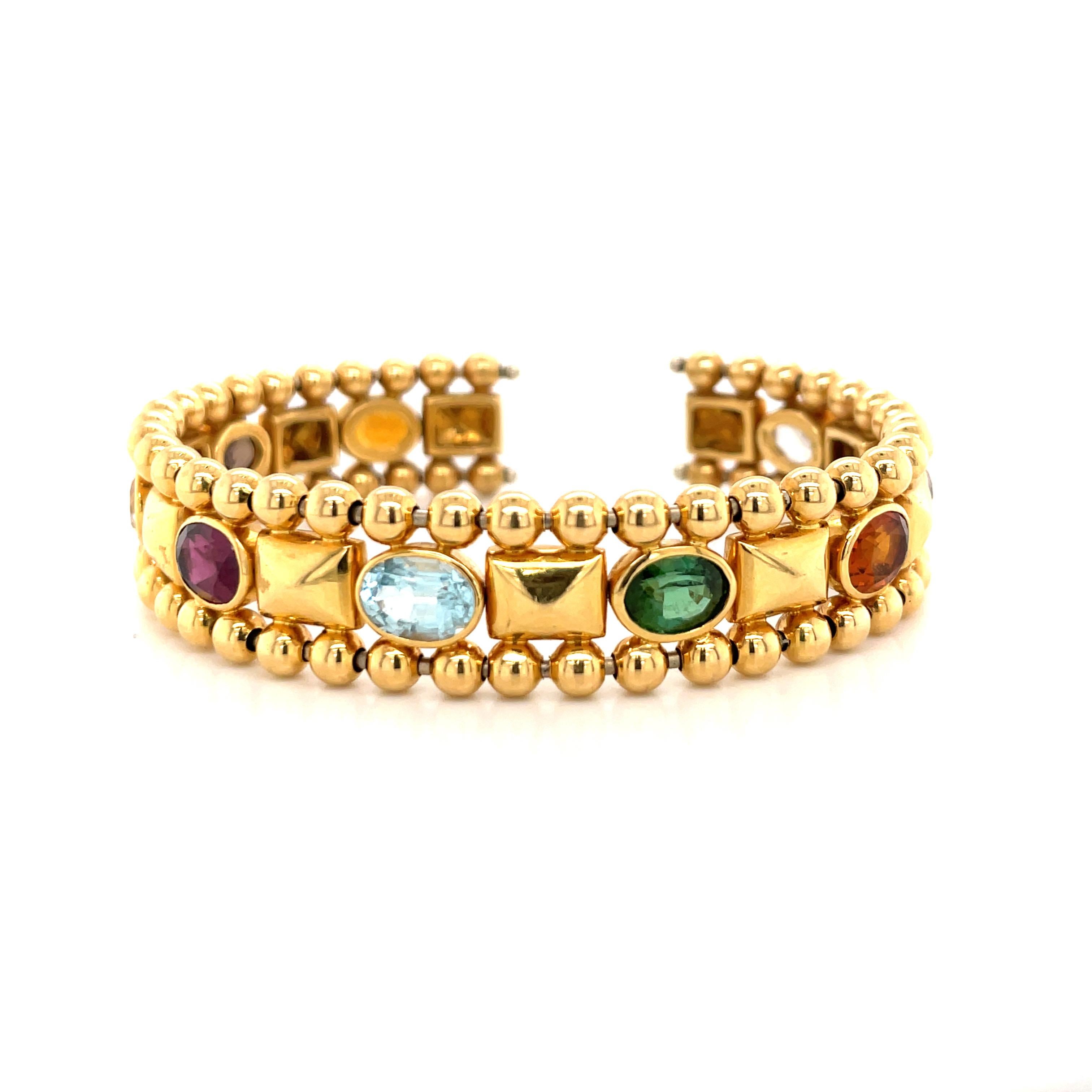 18 Karat Yellow Gold cuff bracelet featuring 9 oval shape semi-precious stones weighing 45.2 grams.
Semi-Precious Colors: White, Purple, Orange, Green, Blue, Red, Smokey Topaz
Very Comfortable on the wrist!