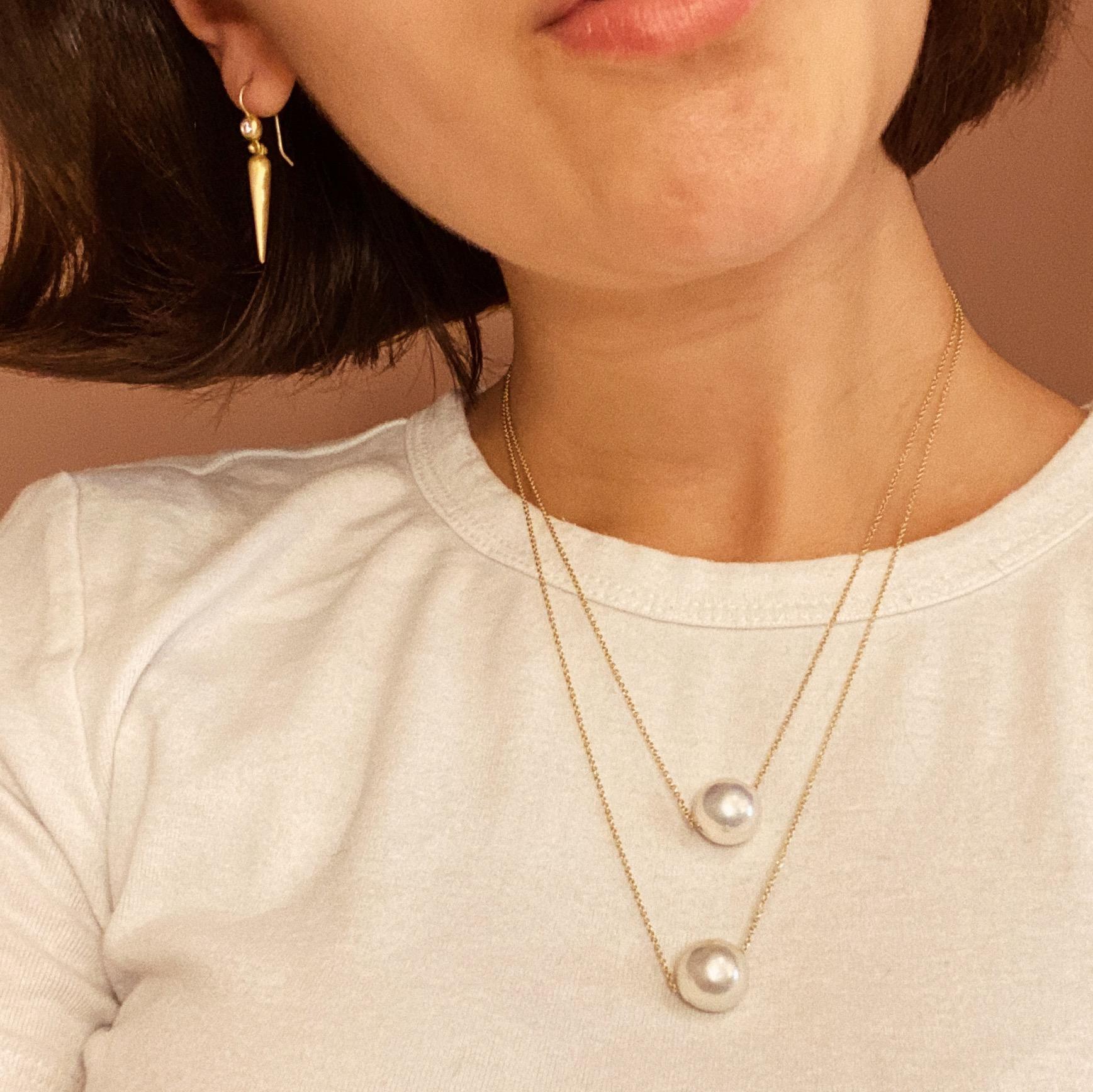 Pendentif en perle unique de Faye Kim. Perle de culture d'eau douce blanche surdimensionnée sur une chaîne câble en or jaune 18 carats. Simple, classique et toujours élégant ! 

Perle 12-13mm
Chaîne réglable de 16 à 18 pouces

Le pendentif