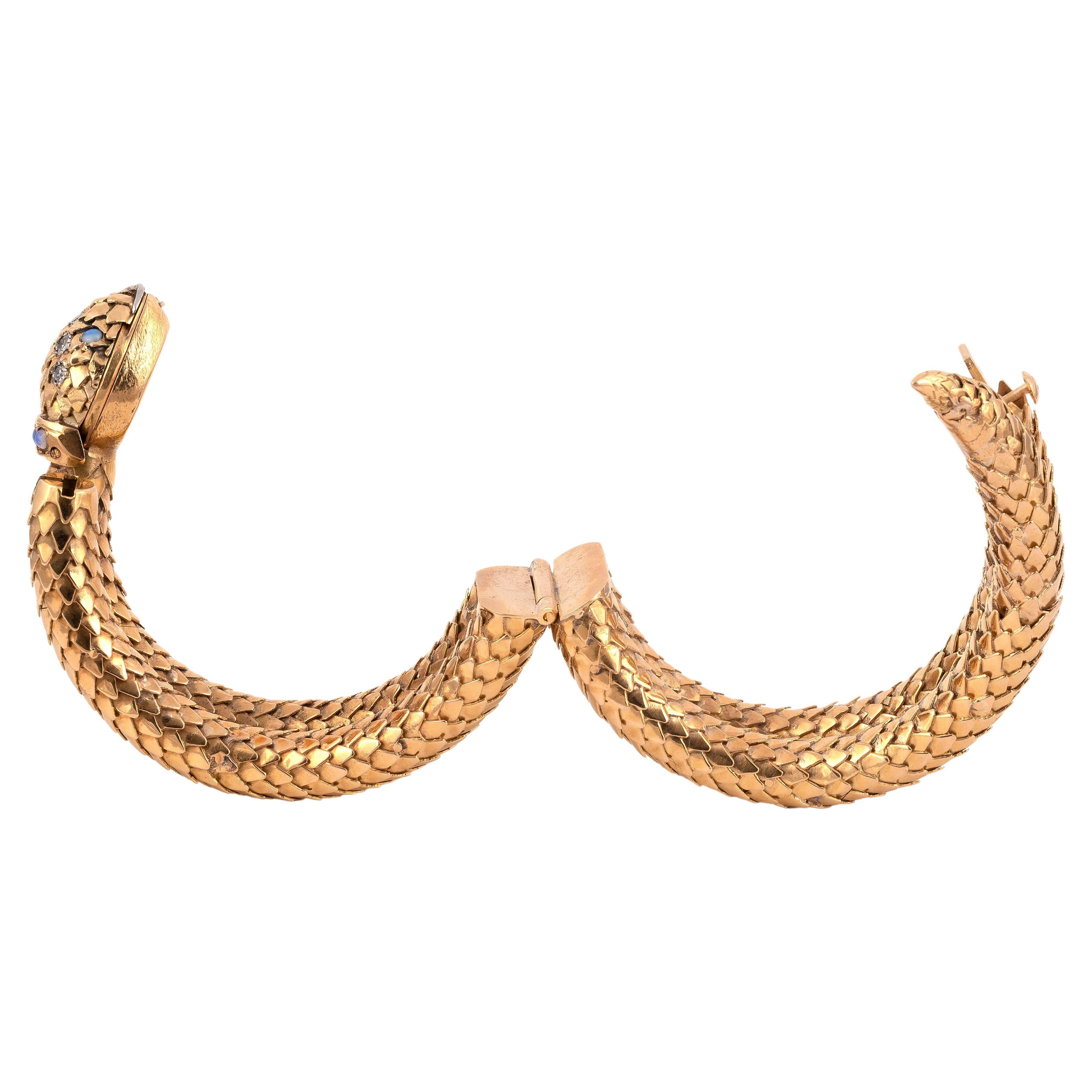 
Misterioso reloj de oro amarillo, con una serpiente, el cuerpo formado por un doble junco cincelado con escamas que se cierra con un trinquete. La cabeza de la serpiente revela un reloj con movimiento mecánico , la cabeza engastada con diamantes