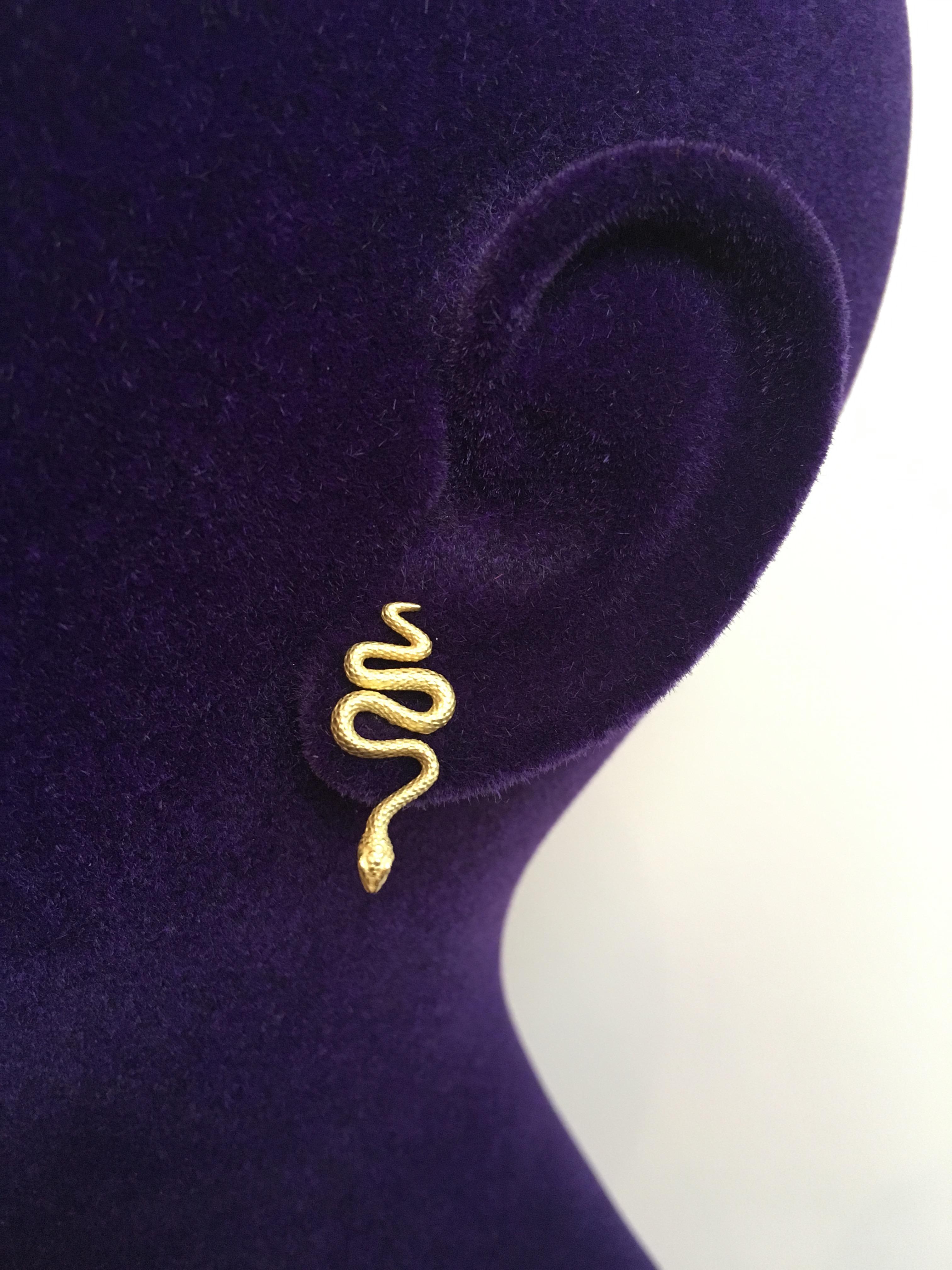 A pair of 18 Karat yellow gold mini snake stud earrings. 

Earrings with post and butterfly.