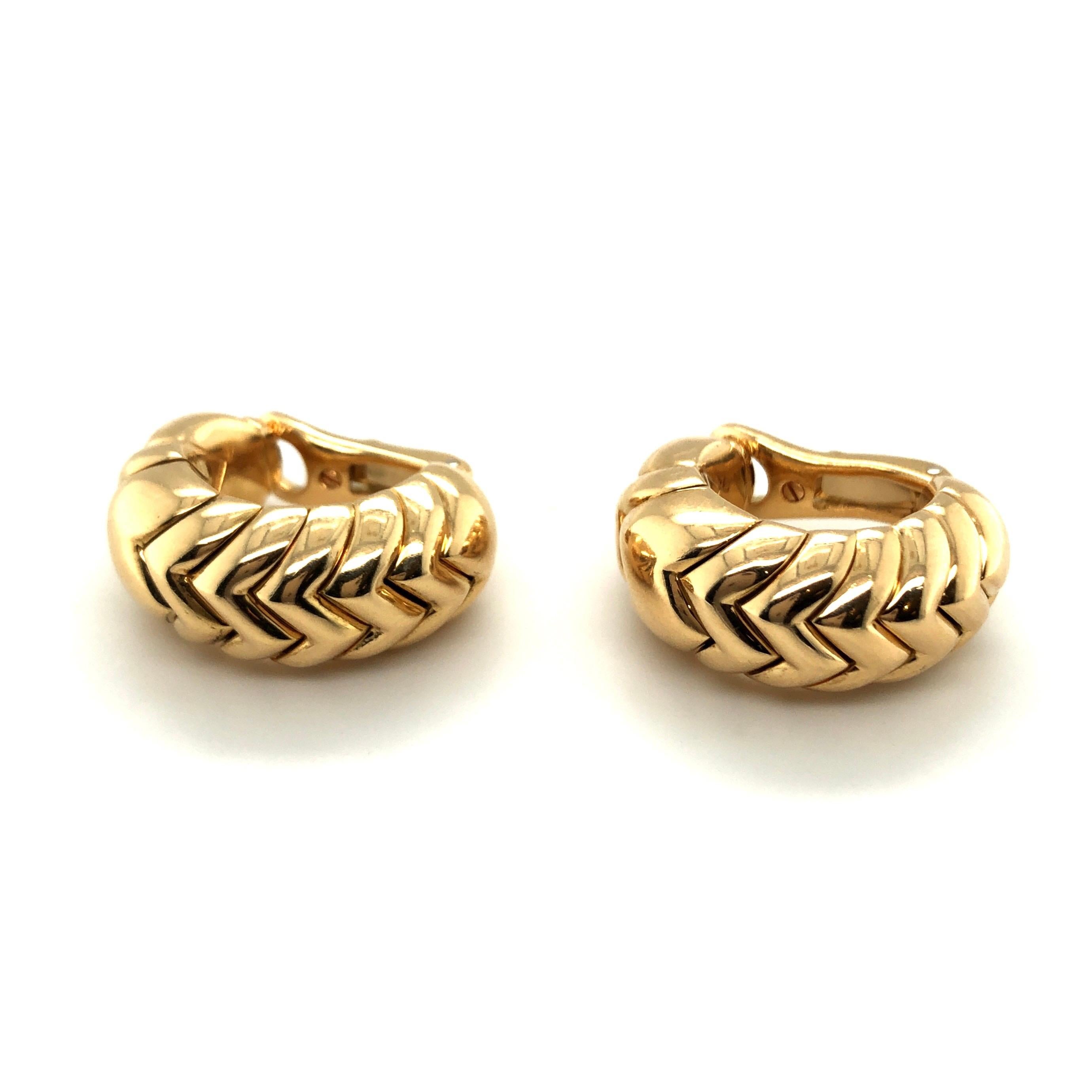 Elegant pair of 18 karat yellow gold Spiga earrings by Bvlgari.
Each half-hoop designed as a series of interlocking polished gold links fashioned into a zig-zag pattern. They are light and comfortable to wear day and night. Spiga was one of