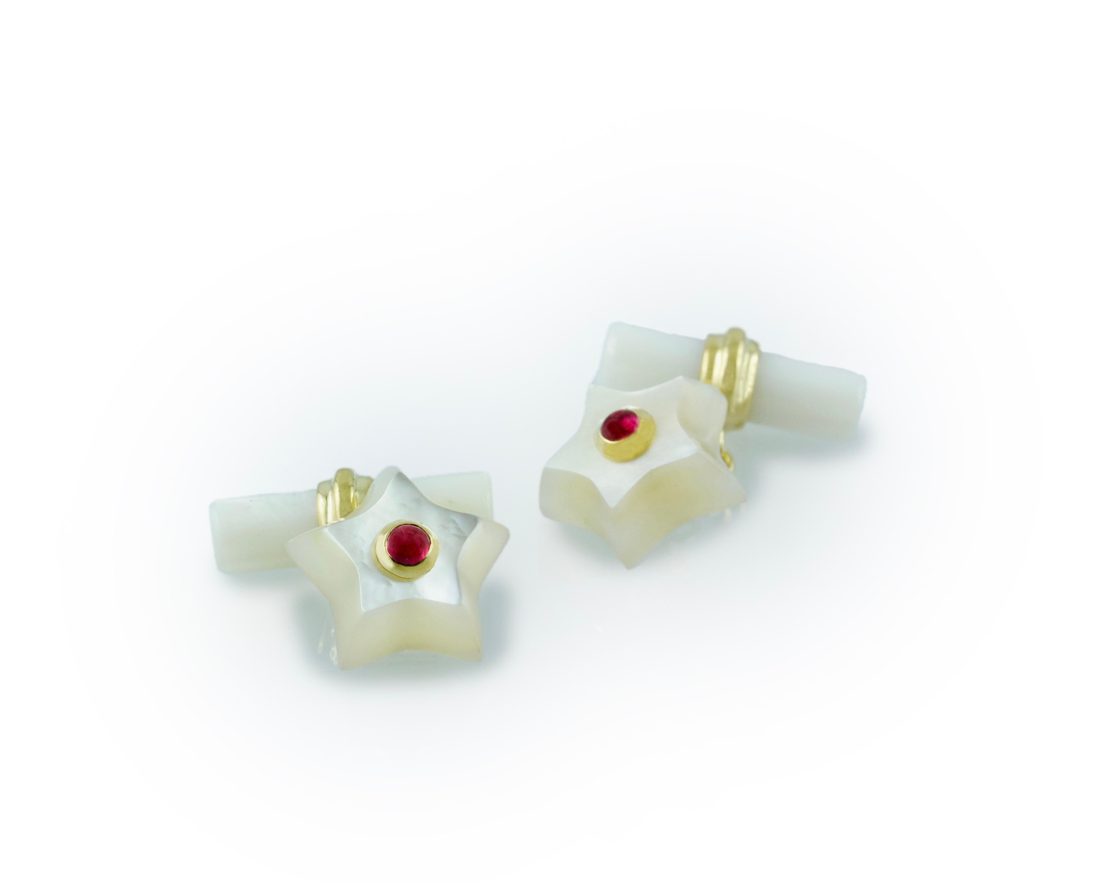 This charming pair of cufflinks is entirely made in mother of pearl, shaped as stars and adorned in the center with cabochon rubies. 
The 18 karat yellow gold post links this element to the toggle, which is a simple cylinder.

Dimensions: 
         