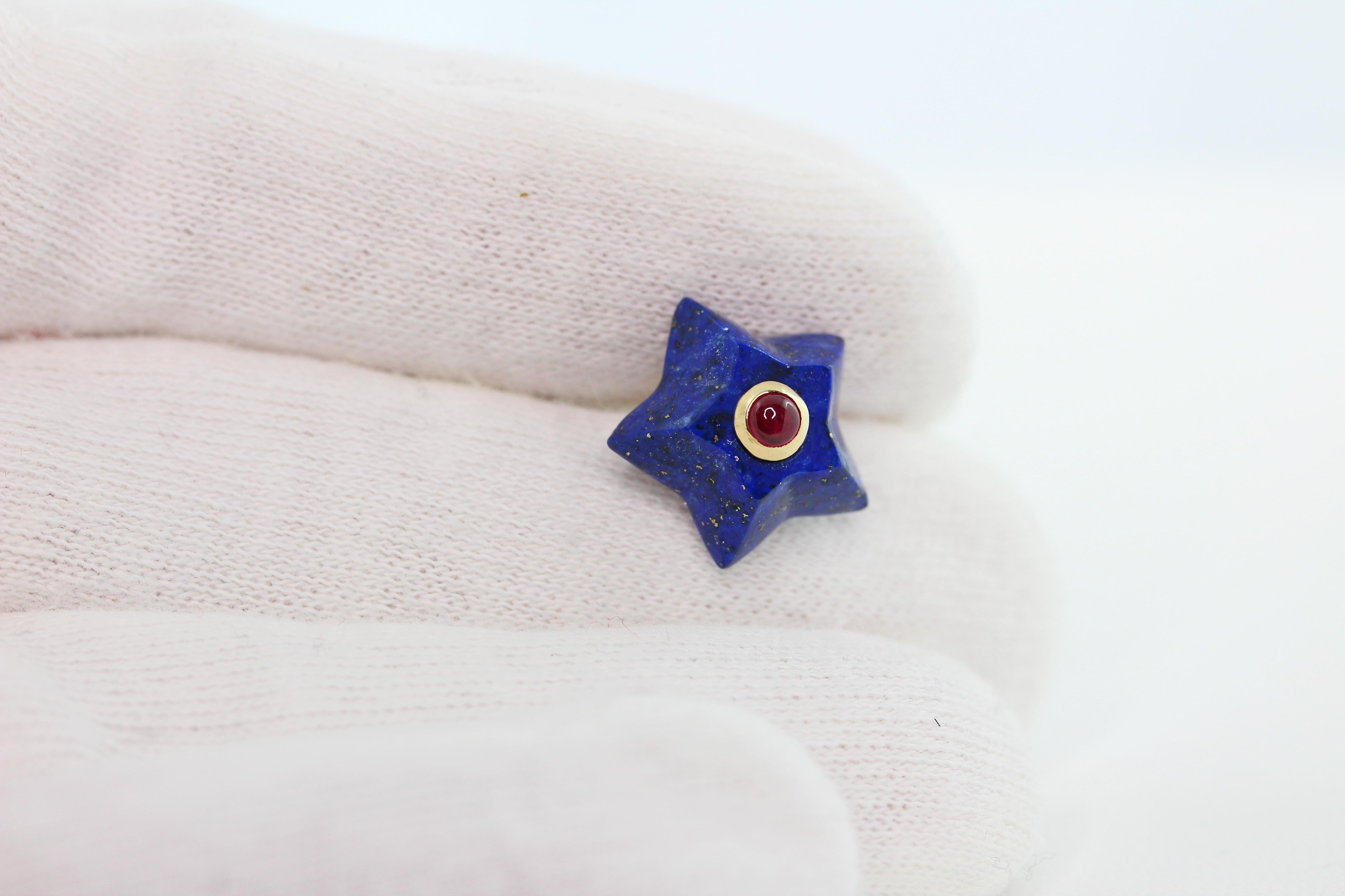This charming pair of stud earrings is entirely hand carved and made in lapis lazuli, shaped as stars and adorned in the center with cabochon ruby. 
The mounting is in 18 karat yellow gold. 

Dimensions:
                    1.4 x 1.4 cm circa
      