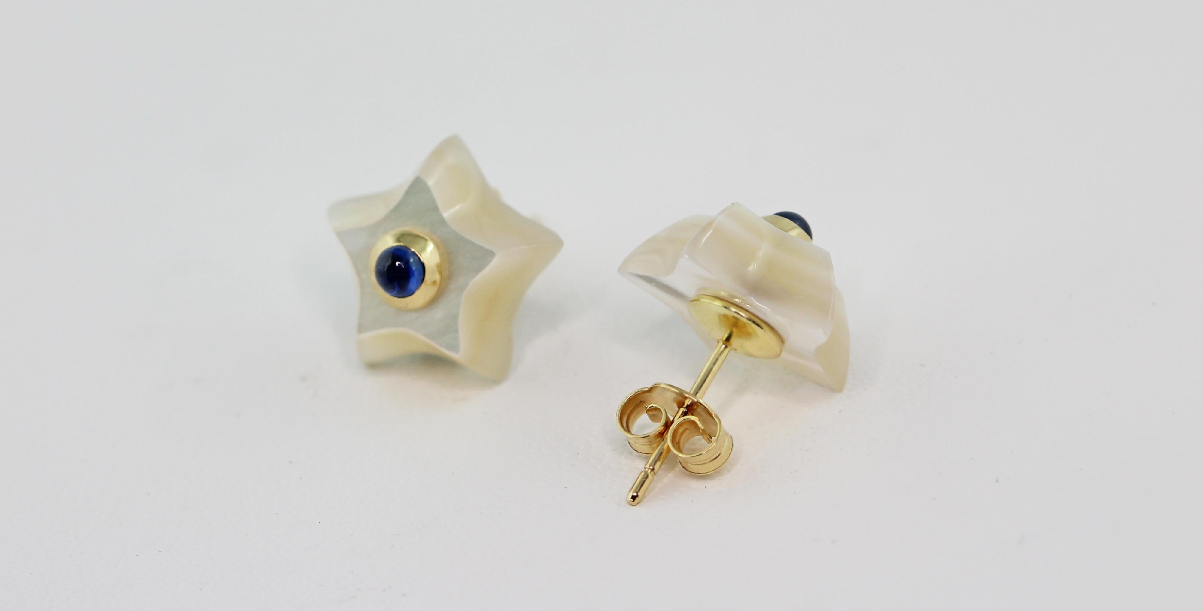 This charming pair of stud earrings is entirely made in mother of pearl, shaped as stars and adorned in the center with cabochon sapphire. 
The routing is in 18 karat yellow gold. 

Dimensions:
                    1.4 x 1.4 cm circa
                