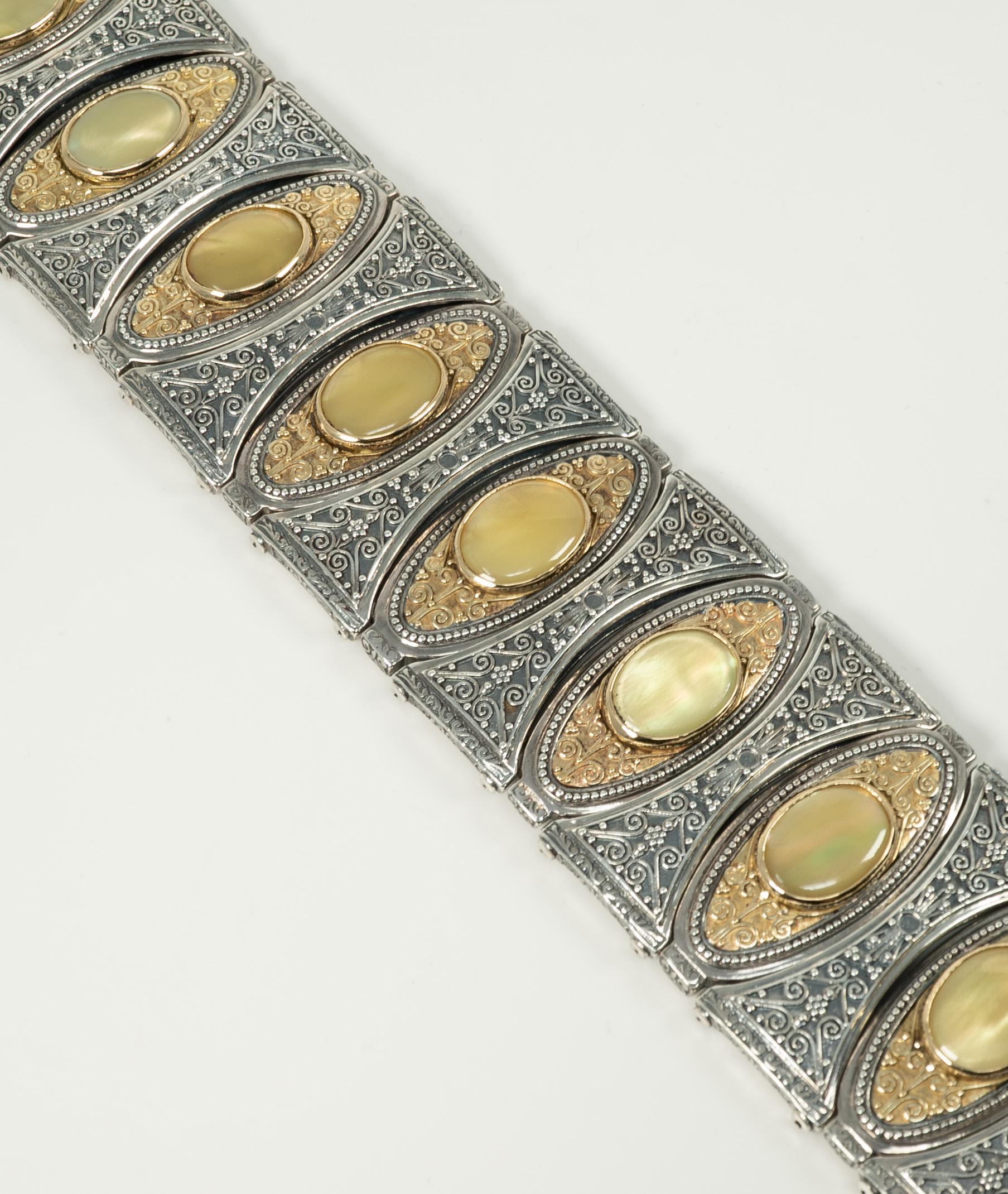 This stunning Konstantino bracelet is in 18 karat yellow gold and sterling silver and features oval-shaped inlays of dyed mother of pearl shell. 