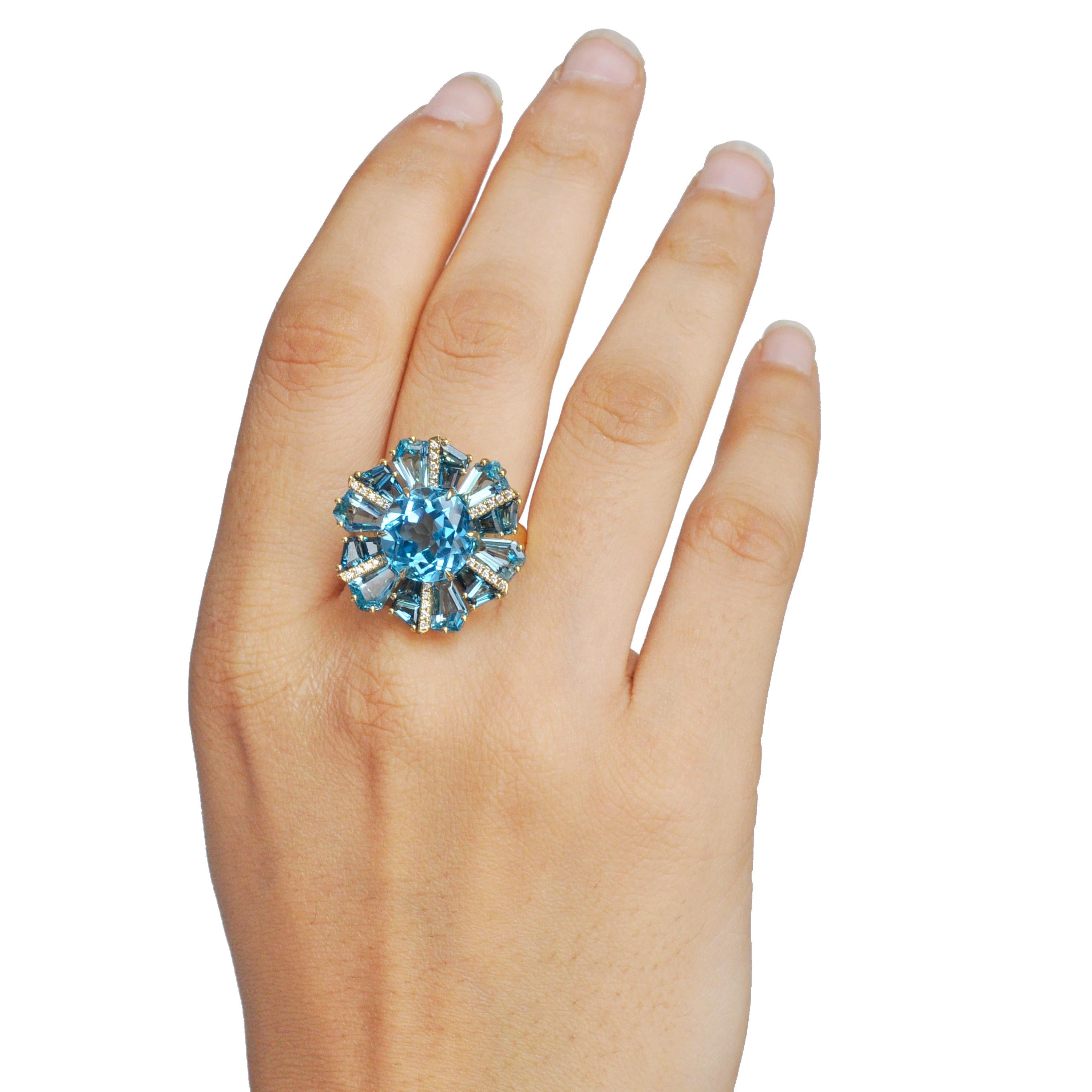 Questo anello da cocktail in oro giallo 18 carati, unico nel suo genere, è un pezzo vibrante che emana eleganza e individualità. Al centro, uno splendido topazio blu svizzero rotondo attira l'attenzione con la sua brillantezza color acqua, che