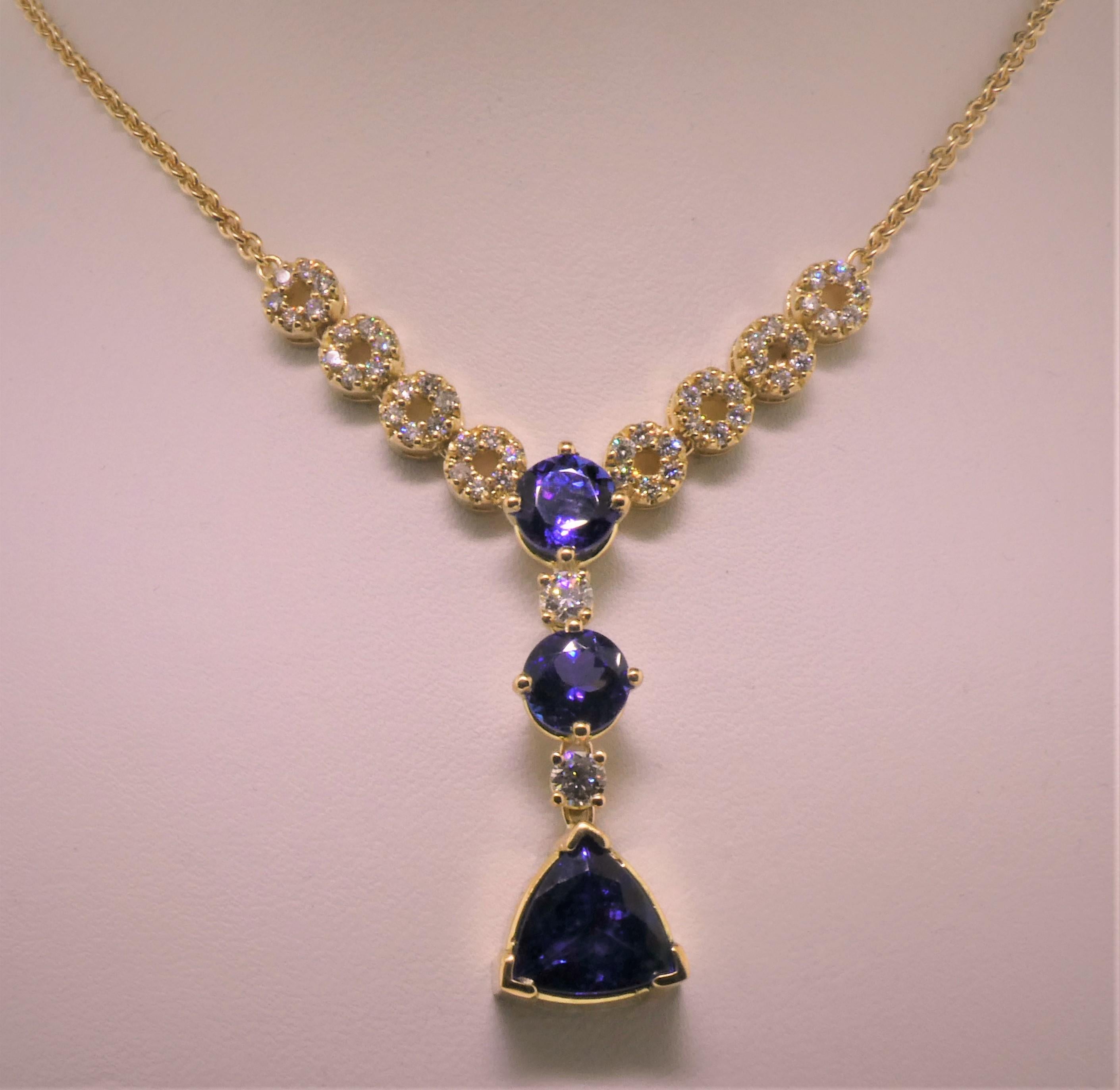 Conceived and designed by Michael Engelhardt, this beautiful Tanzanite (3 stones weighing 6.11 carats) and Diamond (2=0.34 + 48=0.70 Carats) pendant absolutely steals the show.  Light, Lively, easy to wear, dress it up, or dress it down, the stones