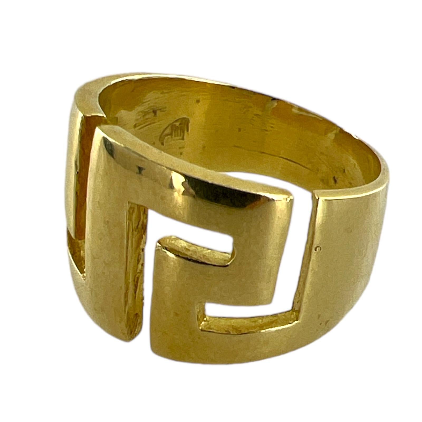 Greek key design ring crafted in 18 karat yellow gold. The band features a cut out Greek key design measuring 15mm in width and tapering down to 6mm in the back. The ring is currently size 9 (can be sized). 