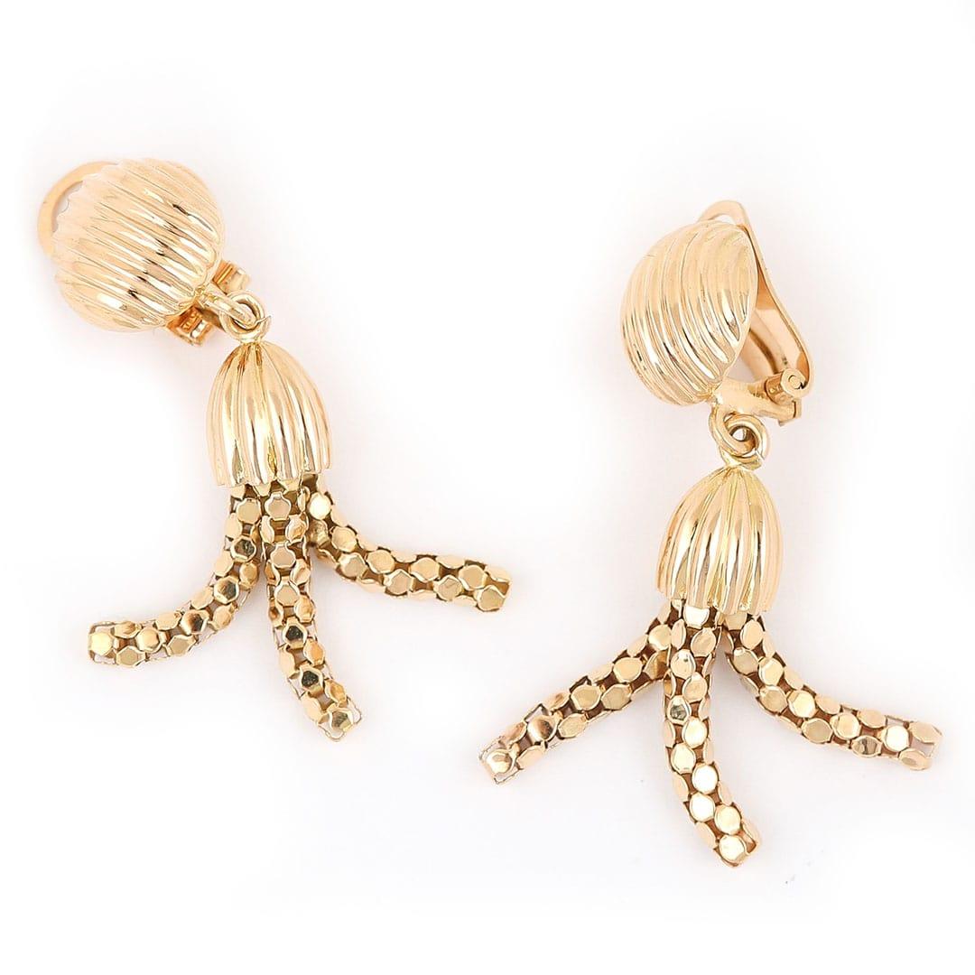 A snazzy pair of modern articulated 18 karat yellow gold clip on tassel earrings. With a contemporary design these are offered in a bright yellow gold finish, the textured ball fitting and cap hold the faceted three strand tassels. These clip on's