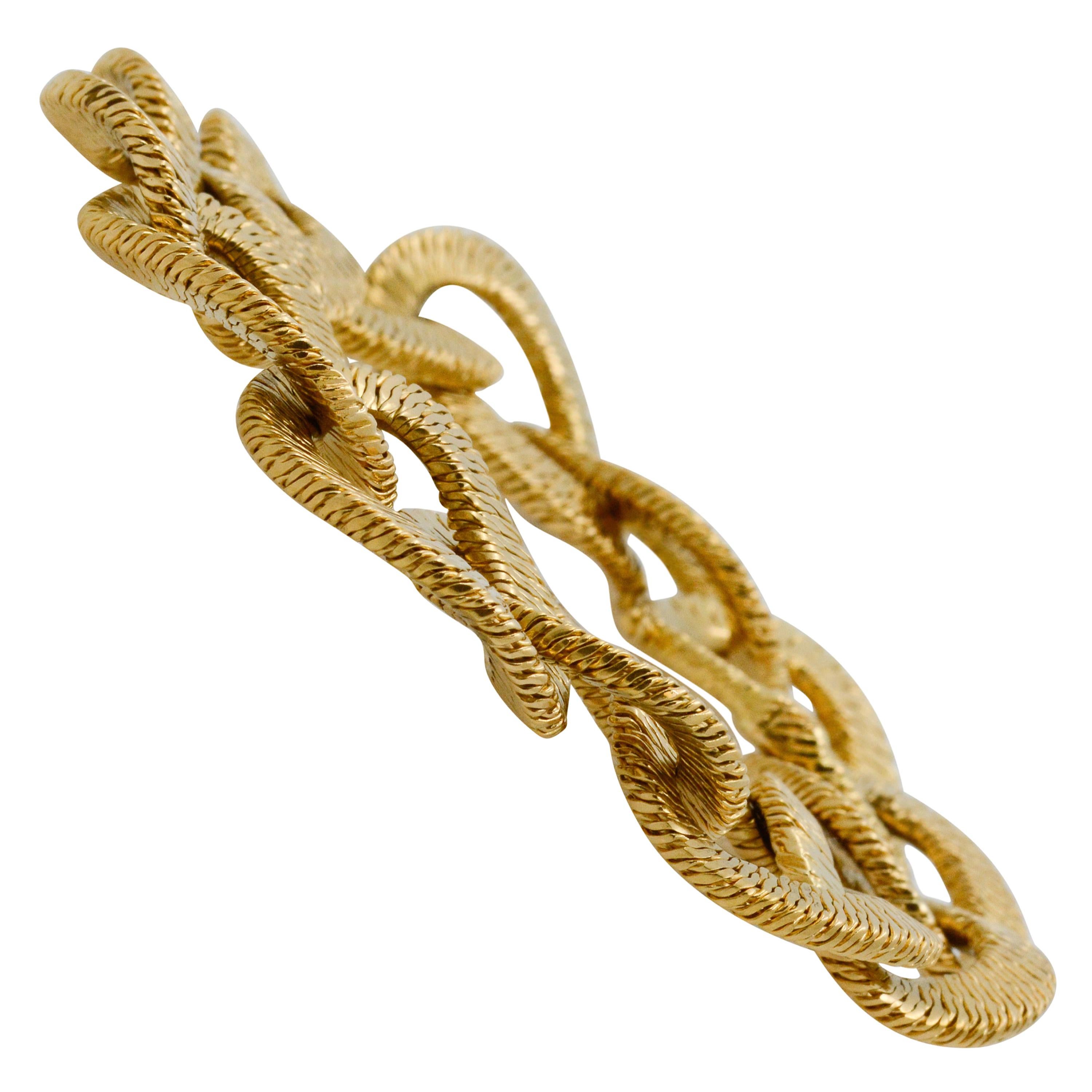 With a unique textured design, this 18k yellow gold curb bracelet measures at 8.25” long and has a hidden clasp. 
