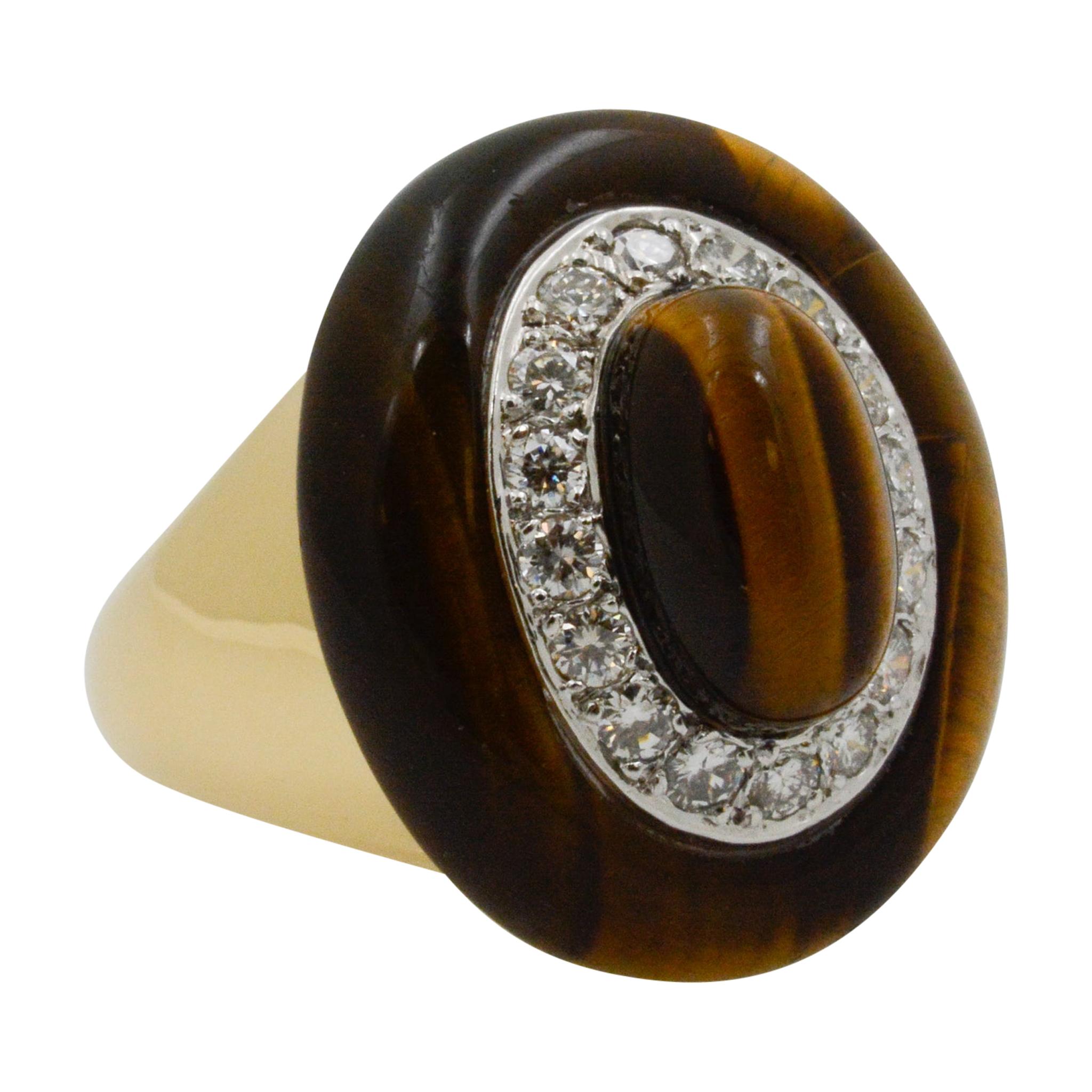 This 18 karat yellow gold ring features a tiger eye surrounded by 16 round brilliant cut diamonds weighing an approximate combined 0.80 carats, with G-H color, and VS clarity. The ring is a size 6. 
