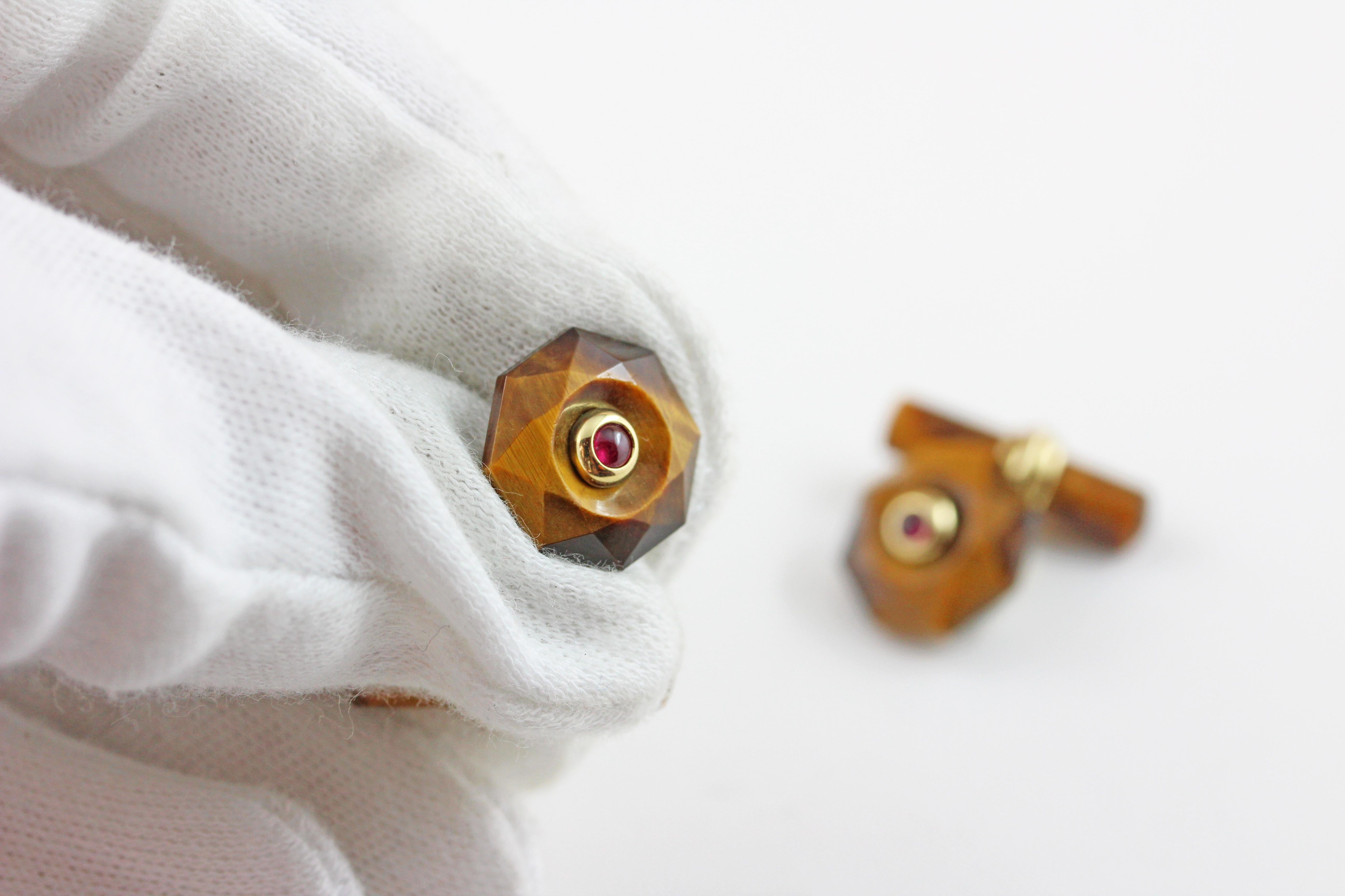 The front face of these exquisite cufflinks has a striking octagonal shape that is convex, multifaceted and adorned in the center with a cabochon rubies.
Both the front face and the cylindrical toggle are in Tiger's Eye, with a post made of 18 karat