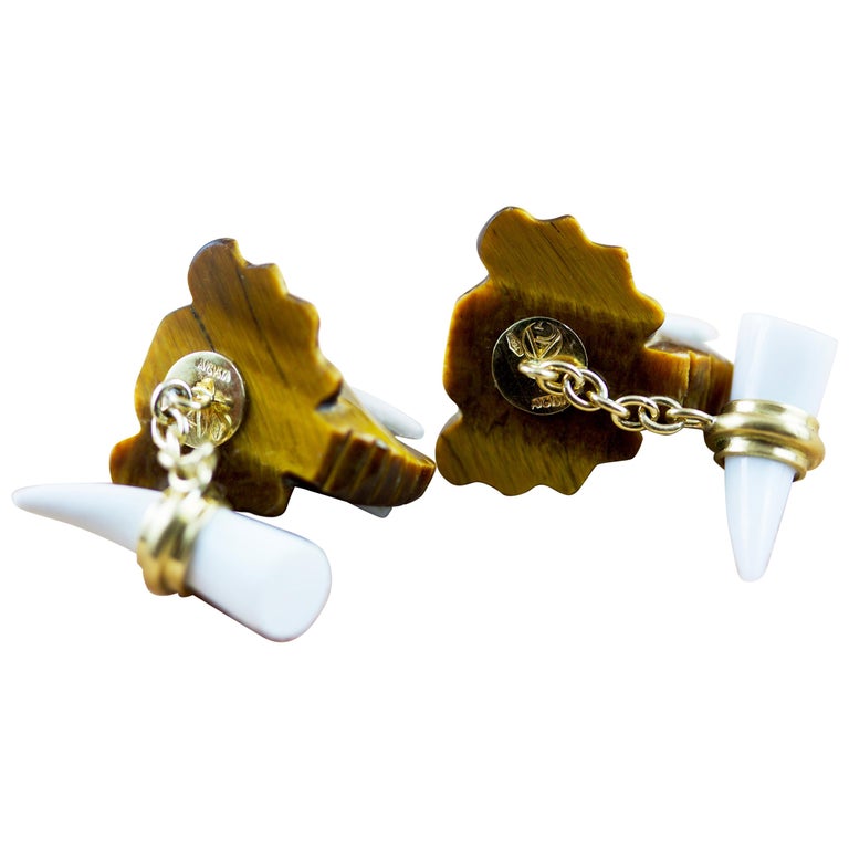 This striking pair of cufflinks is shaped to resemble the head of an elephant and made of tiger’s eye stone. The tusks are in white agate and the eyes are diamonds. The post in yellow 18k gold connects the front with the toggle made of white agate