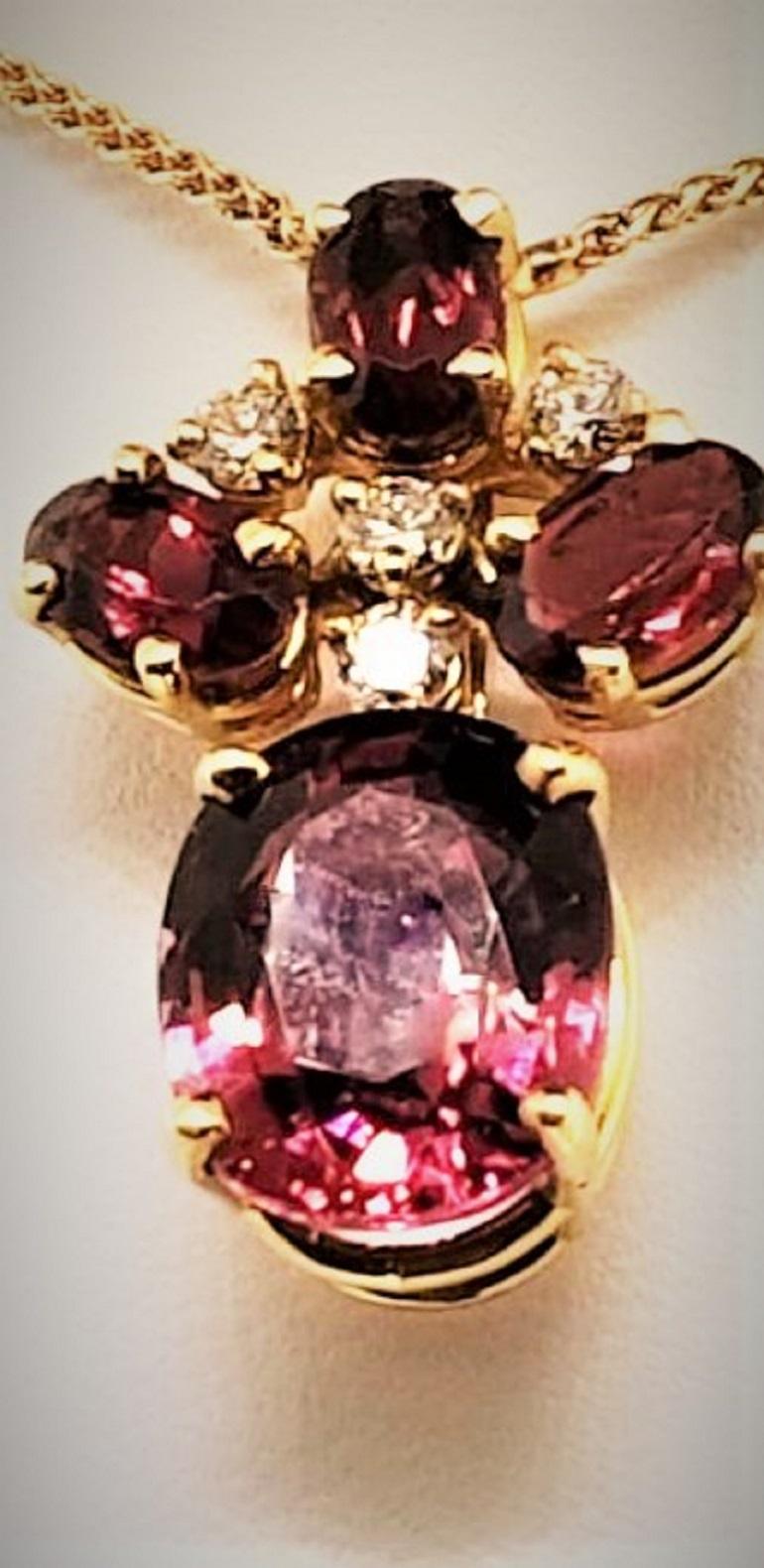 Designed by Michael Engelhardt, this pendant features 4 matching red Tourmaline stones that weigh 4.94 carats.  Interspersed in the pendant are 4 diamonds that weigh 0.12 carats.  The mounting and chain are made of 18 Karat Gold and the chain
