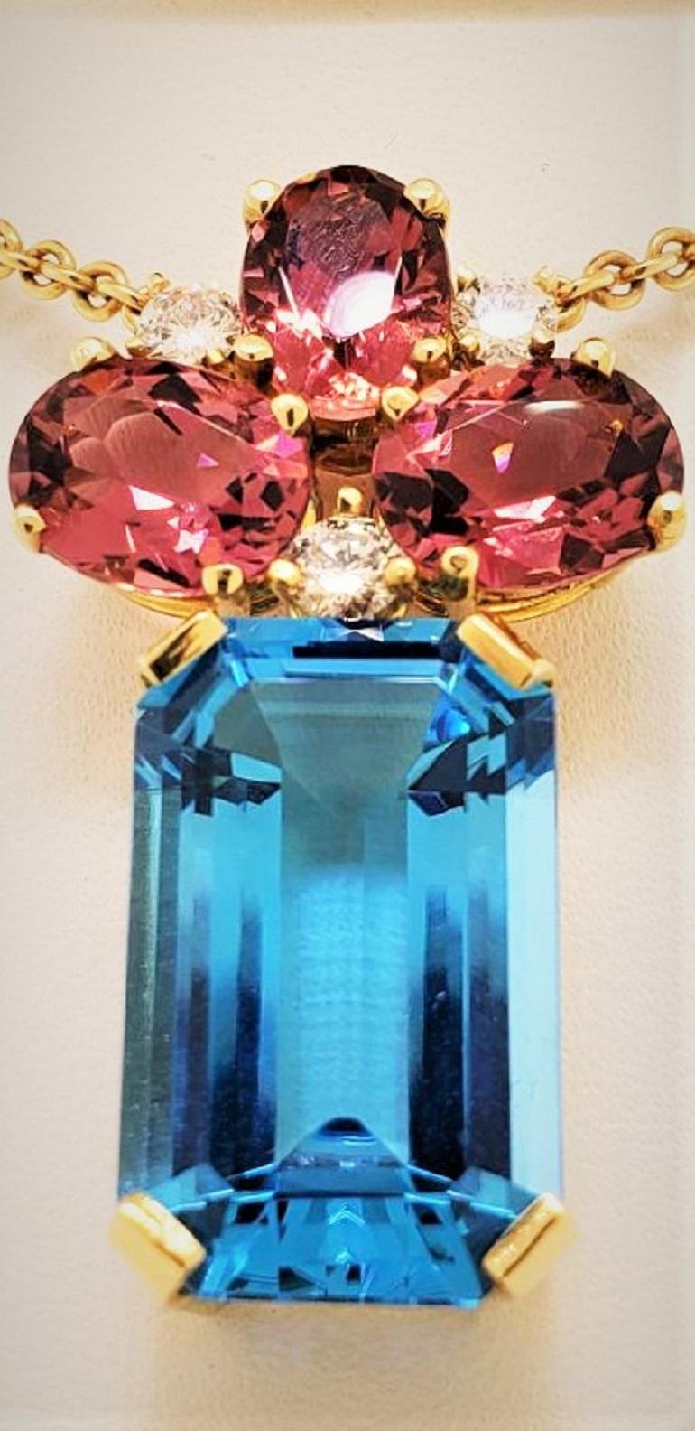 Blending colors and matching hues is a specialty of our company.  The 3 Tourmalines in this pendant blend perfectly with the larger Blue Topaz and bring both stones to life.  Weighing 5.55 carats and set with 3 diamonds that weigh 0.32 carats, the