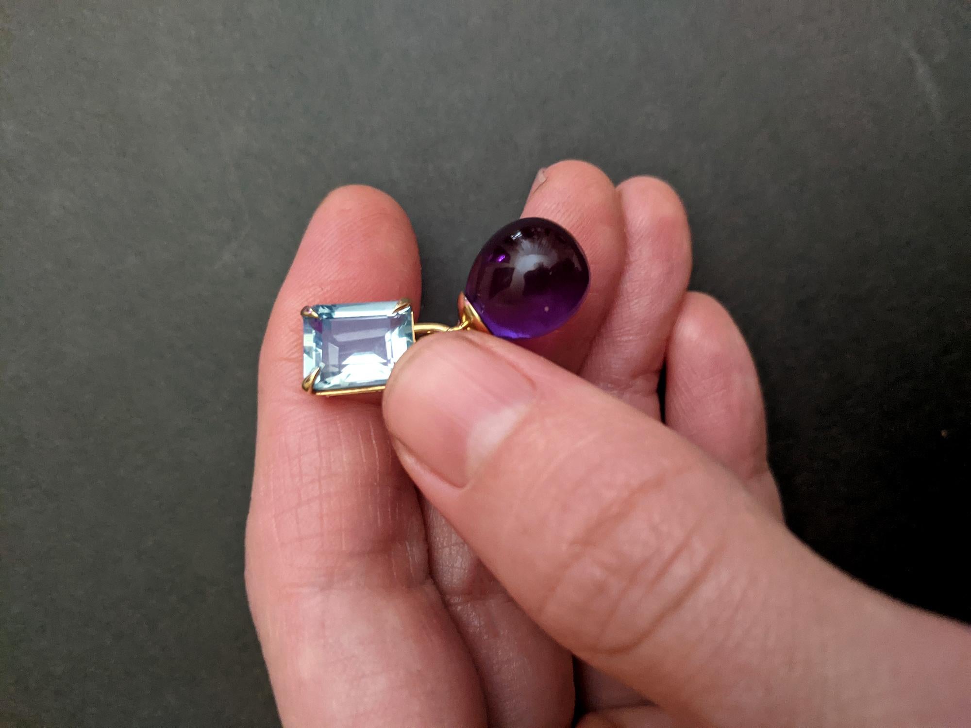 This contemporary transformer drop brooch showcases the elegance of 18 karat yellow gold, featuring a detachable amethyst gemstone in a drop cut. The piece is adorned with a natural ruby, weighing 0.9 carats and measuring 0.3x0.2 inches (7.5x5.5 mm)