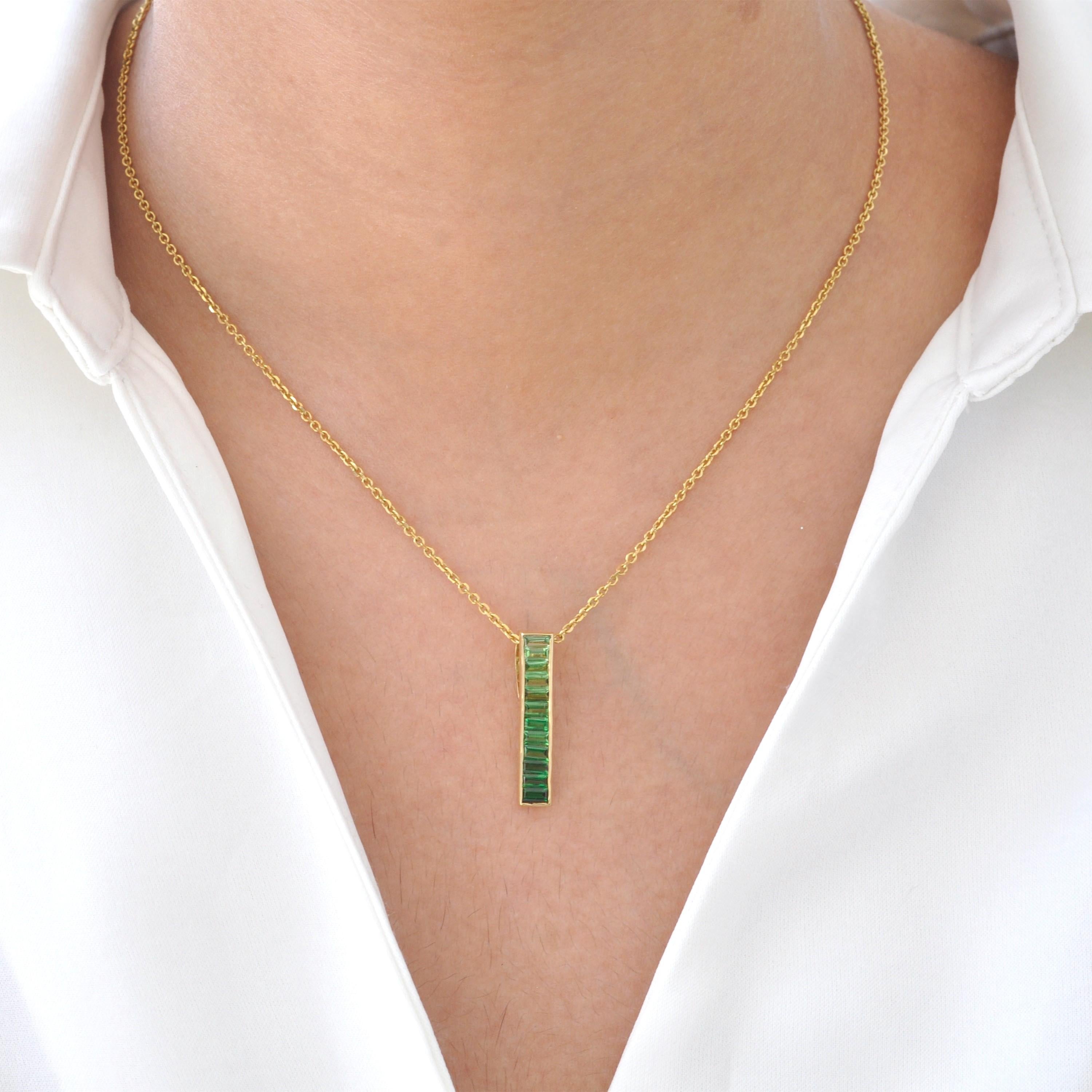Adorn yourself with the exquisite allure of the 18K Gold Tsavorite Baguette Bar Pendant, a graceful fusion of nature's beauty and contemporary elegance. This pendant showcases a sleek bar design, meticulously embellished with vibrant green tsavorite