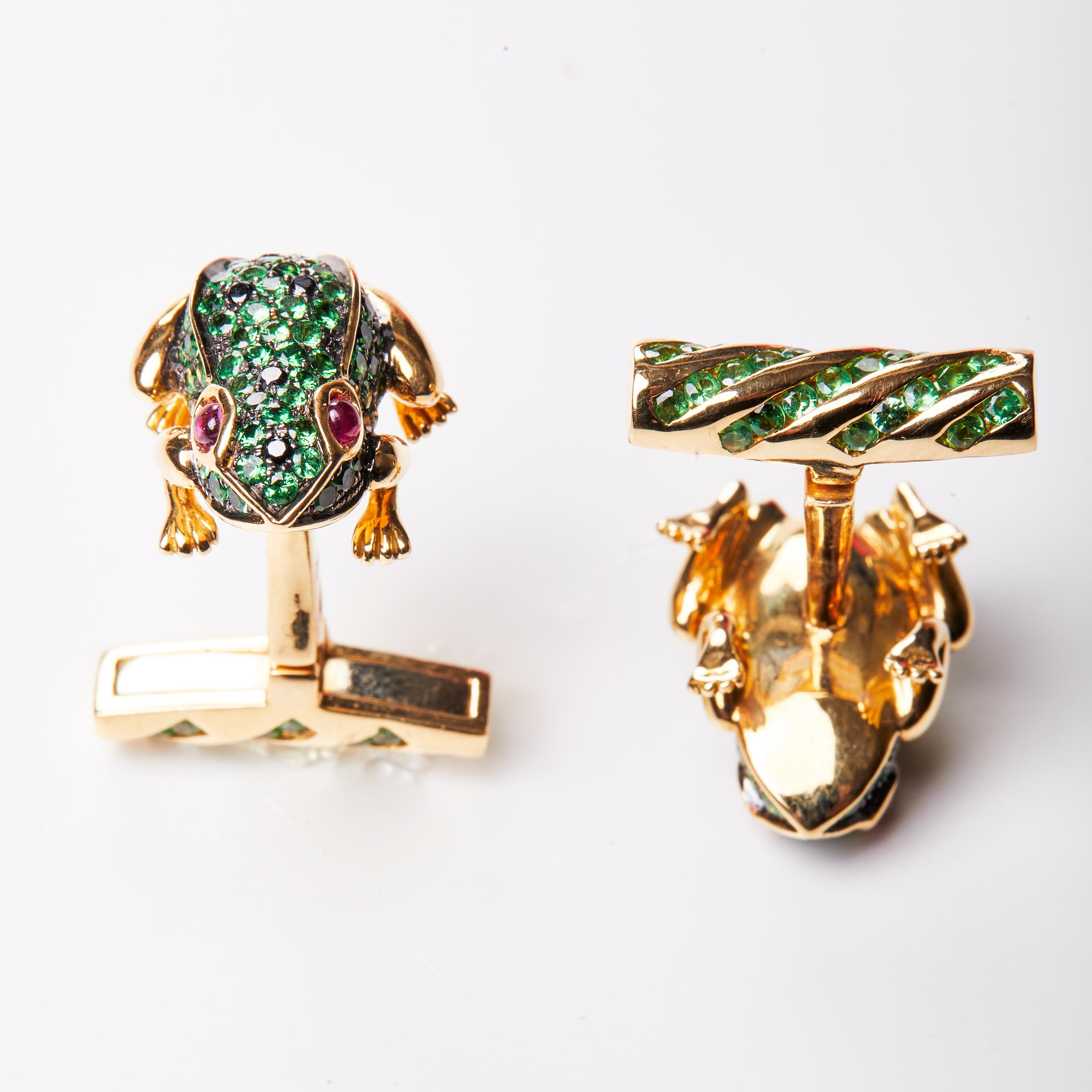 A unique pair of 18 Karat Yellow Gold and multi- coloured stone cufflinks. The cufflinks feature a frog shaped pavé set with coloured stones consisting of Tsavorite, Black Diamonds and cabochon cut Ruby. These striking cufflinks are made to emulate