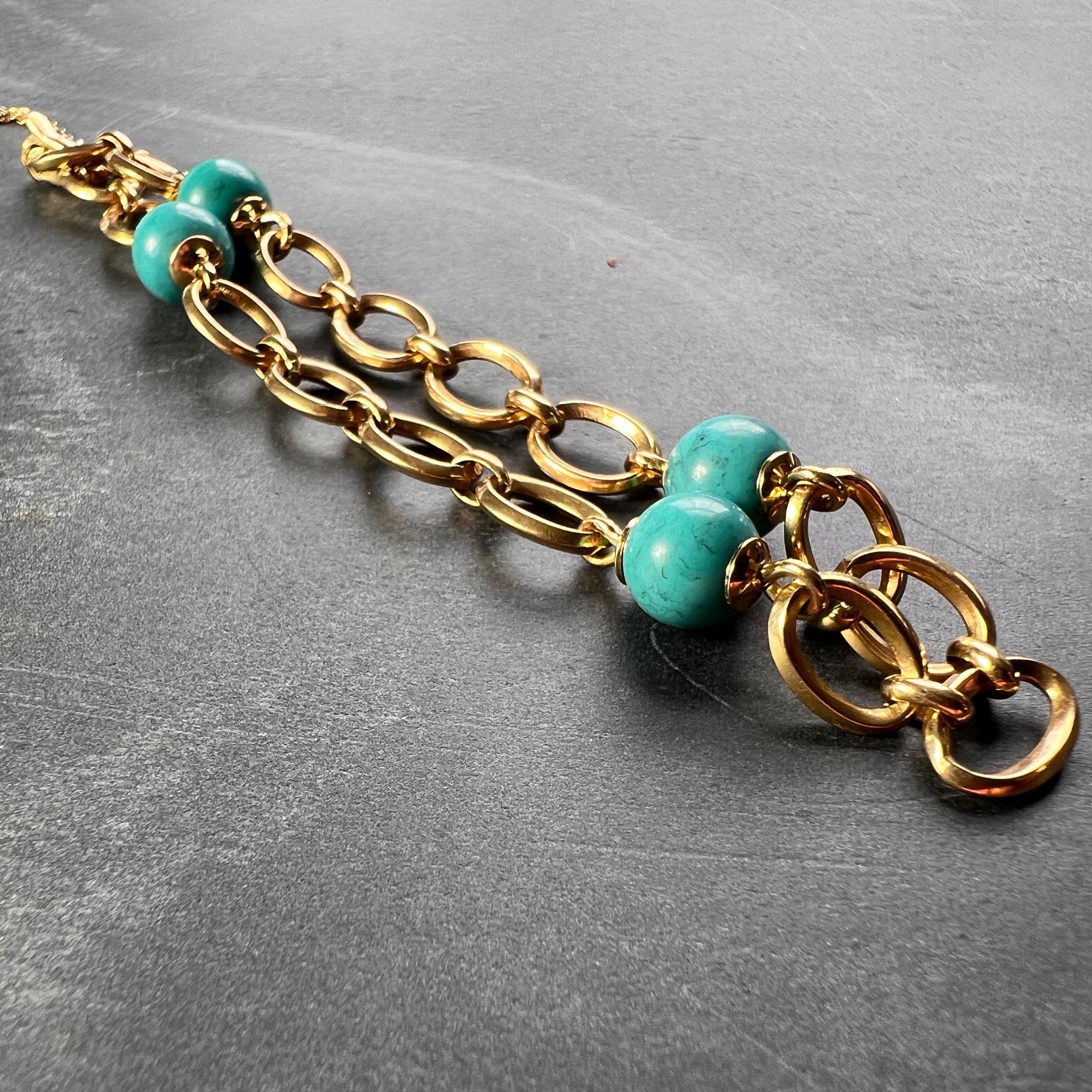 An 18 karat (18K) yellow gold bracelet designed as elongated links set with four evenly spaced round natural turquoise beads. Stamped with the owl mark for 18 karat gold and French import. 7.5” long. With safety chain for added