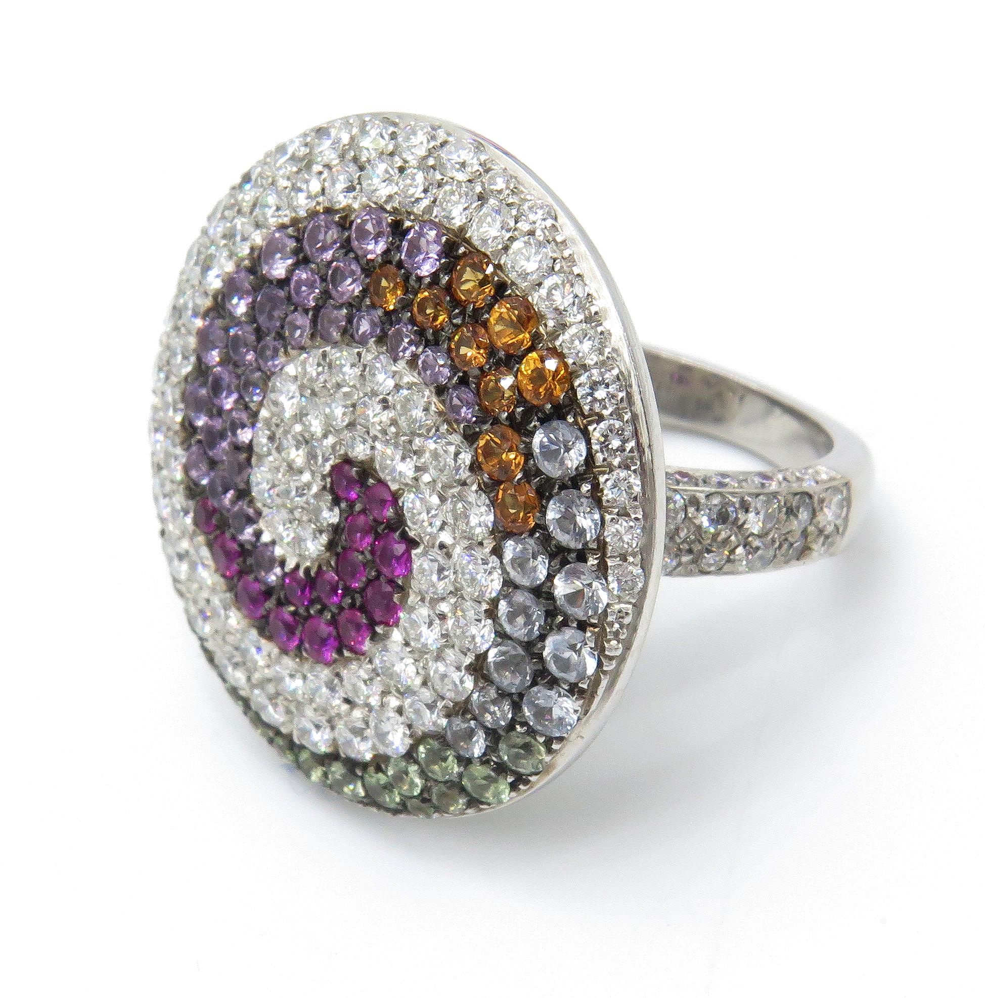 18K White Gold Valente Milano Swirl Ring with pave diamonds and multi-color sapphires. The fascinating arrangement of jewels that embellish the top of this fabulous ring, combine 2.80 carats of diamonds with a spiral of 2.72 carats of multi-colored