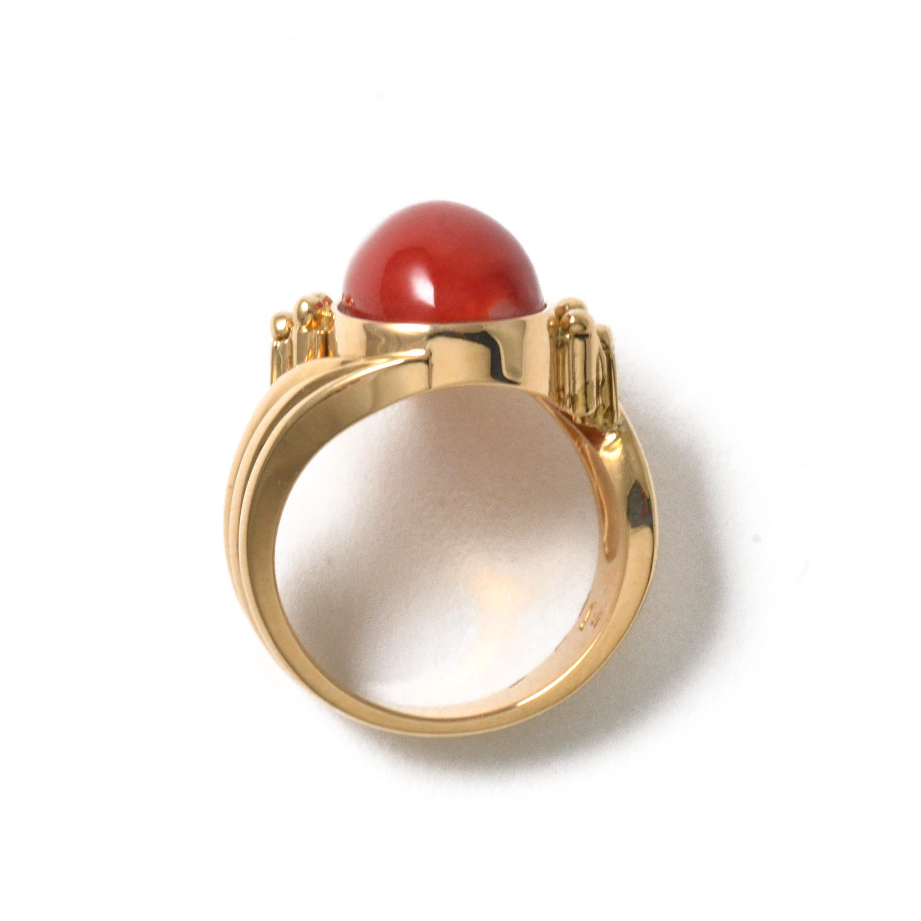 Pear shaped chiaka sango (oxblood coral) is the centerpiece of this very rare, well crafted 18 karat yellow gold ring, which was made about 40 years ago. The very dark red coral has a large, wide shape with substantial thickness and weight. The bold