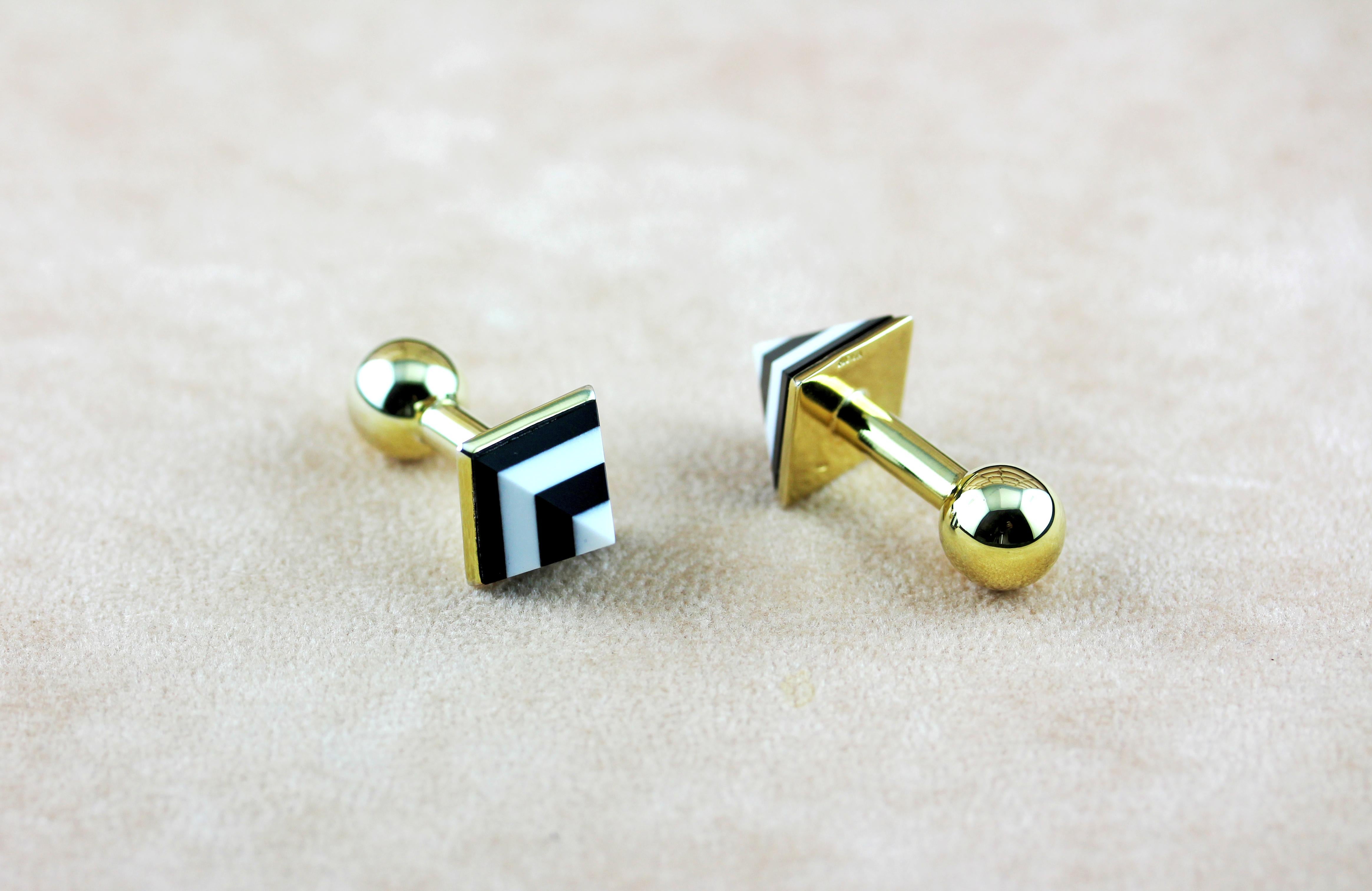 This superb pair of cufflinks feature a spherical toggle and minimalist post in 18 karat yellow gold , while the front face is in the shape of a pyramid mounted featuring layers of white agate and onyx alternating for a timeless effect. 

All