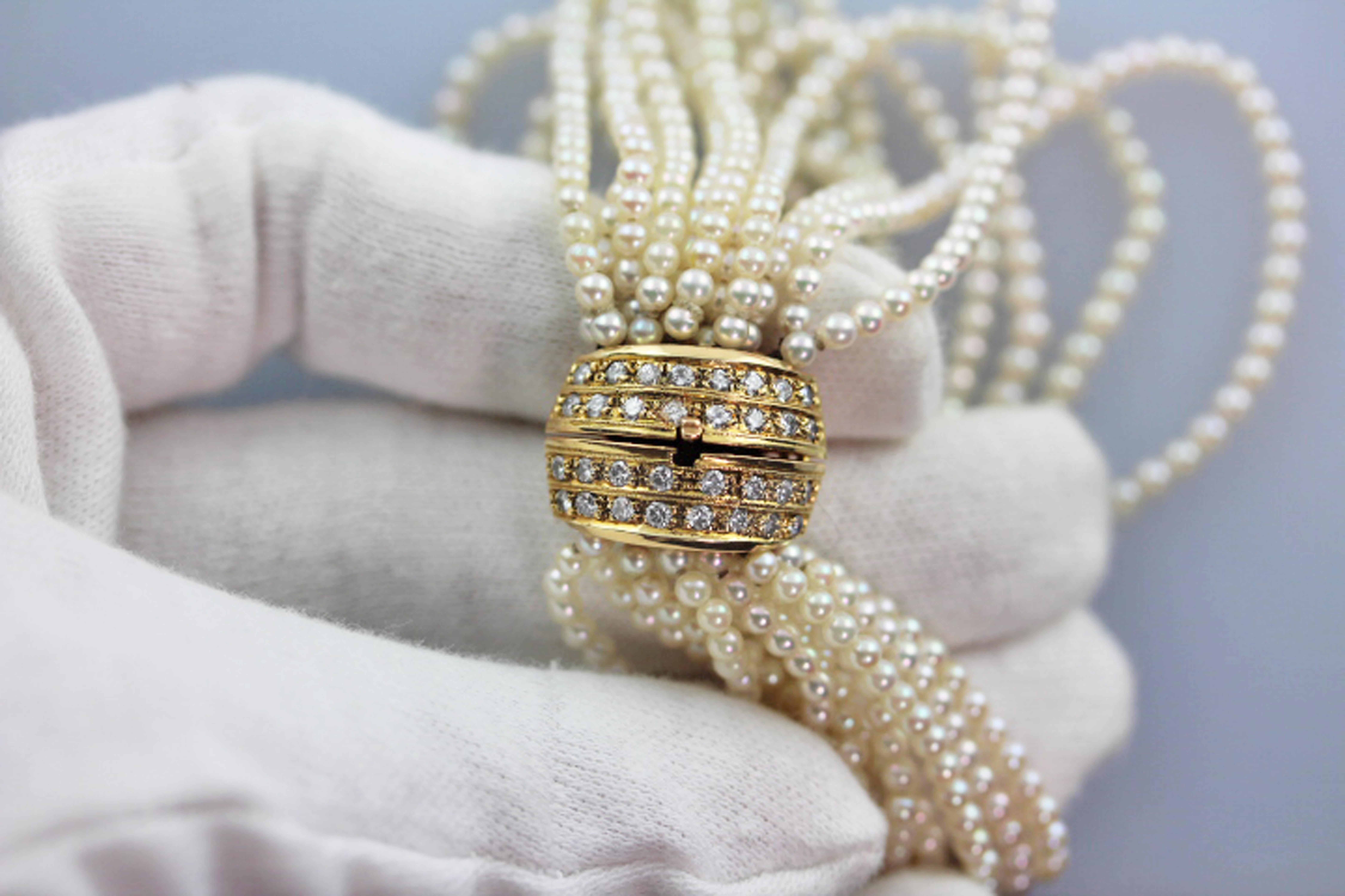 This breathtaking vintage bracelet features 11 strands of beautiful round cultured pearls with a large clasp crafted from solid 18kt yellow gold. 
The lovely pearls are well matched in size, at approximately 3 mm each, and have a gorgeous white