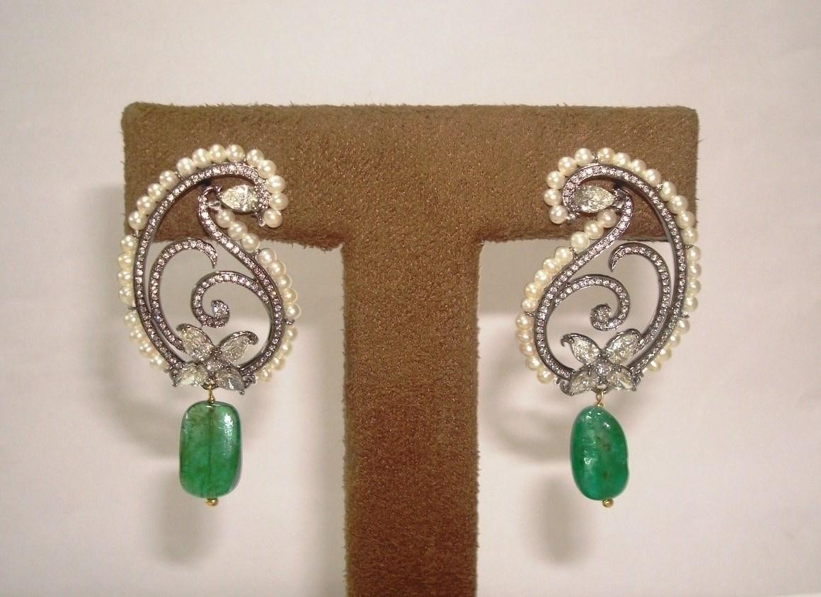 Inspired from our favourite shape the paisley, brilliant cut diamonds are set in a single line. Natural round keshi fresh water pearls are very meticulously strung on the border of the earrings. A natural Zambian emerald tumble bead oscillates at