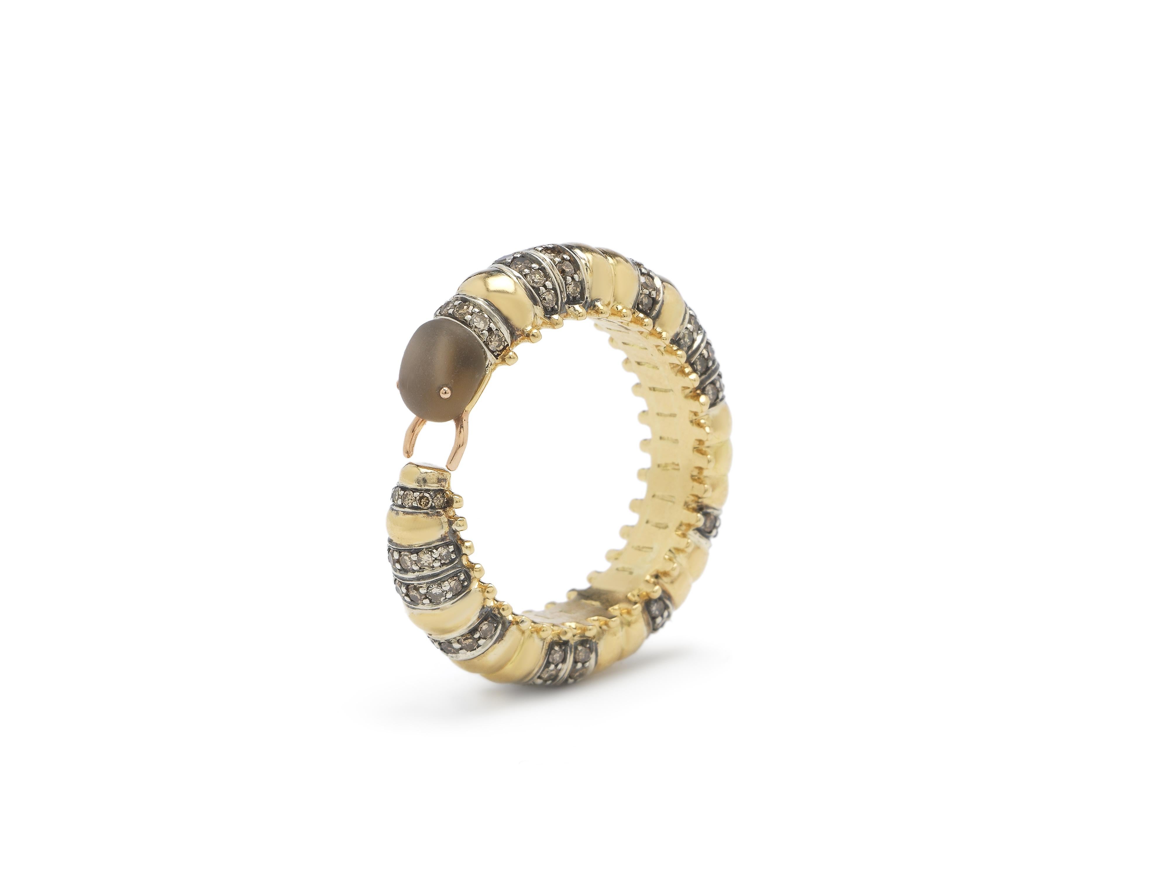 A millipede curves around the finger to form this unique, head-turning eternity ring. The ring is fashioned in 18k yellow gold and sterling silver, with the insect boasting brown diamond embellishments along its body, with its head carved in ash