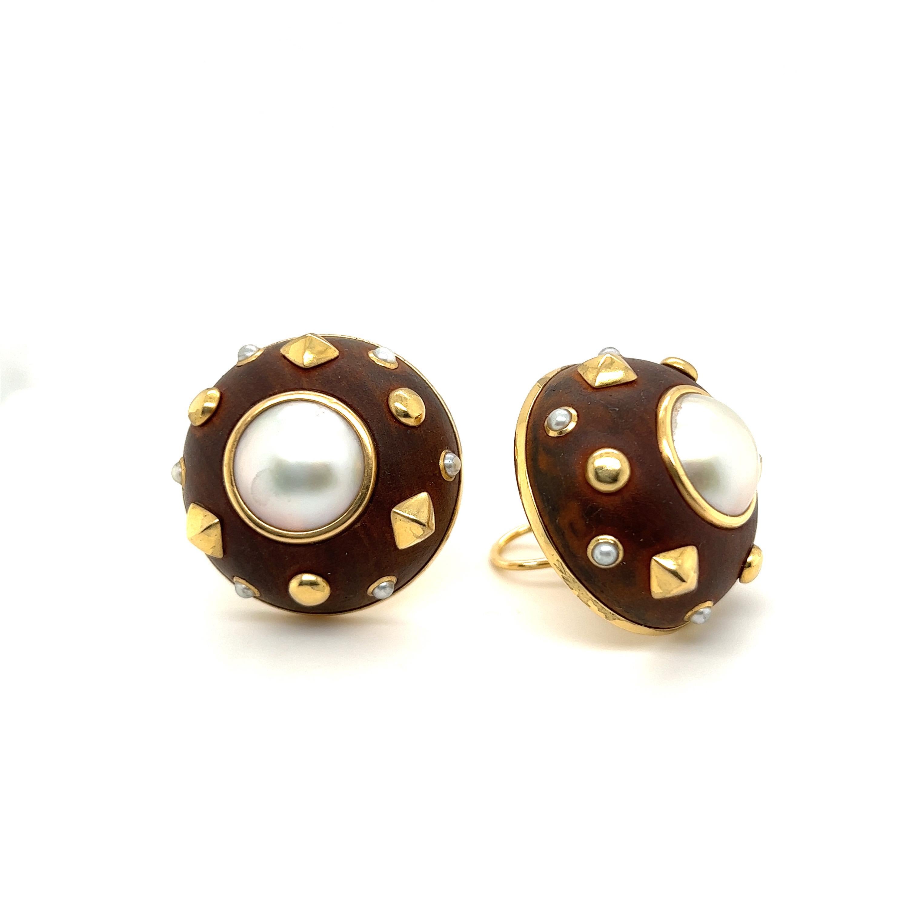 Striking pair of 18 karat yellow gold, wood and pearl earrings by Trianon, 1980s.
Large round earclips crafted in 18 karat yellow gold and set with wood, 2 mabe pearls of 13 mm ( 0.5 in ) diameter and 12 smaller seed pearls. 
They are completed by