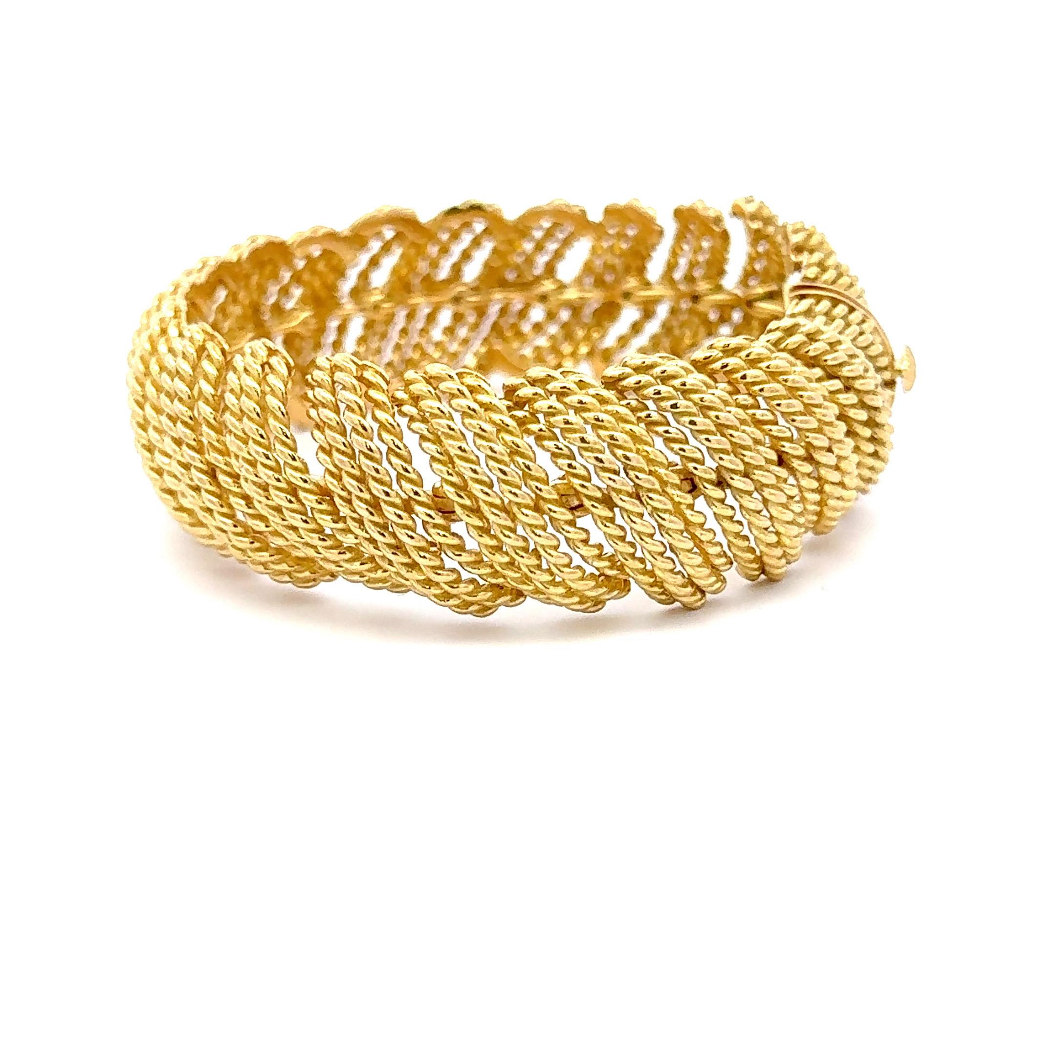 18 Karat yellow old link bracelet featuring a woven scallop motif design weighing 73.8 grams. 
Beautiful design! 